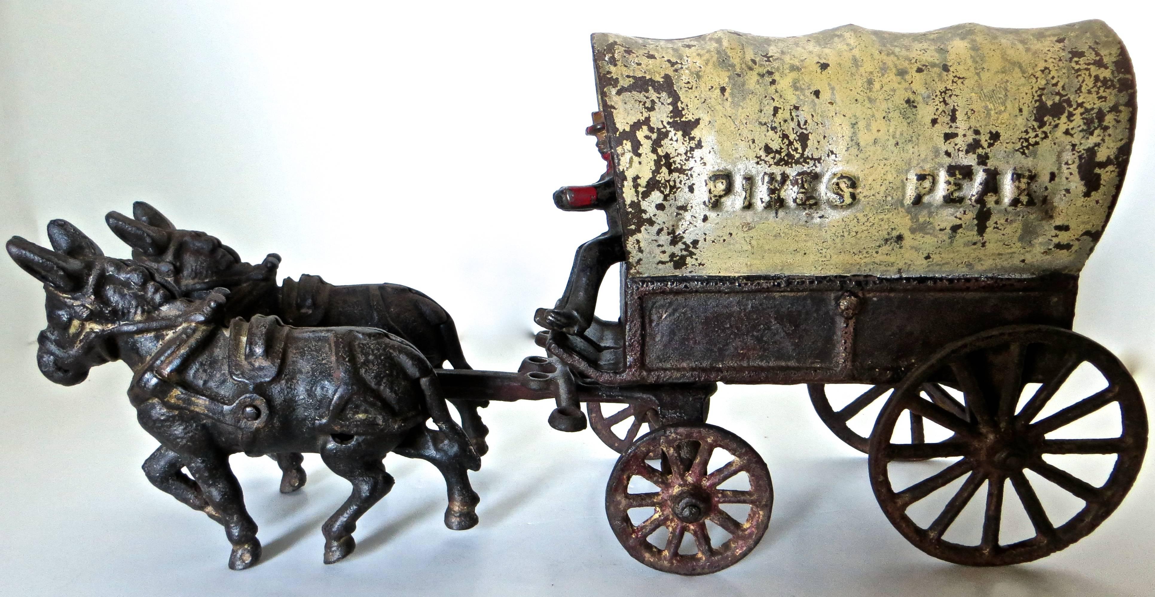 Original cast iron mule drawn covered conestoga wagon with original driver, wheels, and mules. A conestoga wagon was what the pioneers and gold seekers used to transport all of their belongings for the long journey westward. It was heavier than most