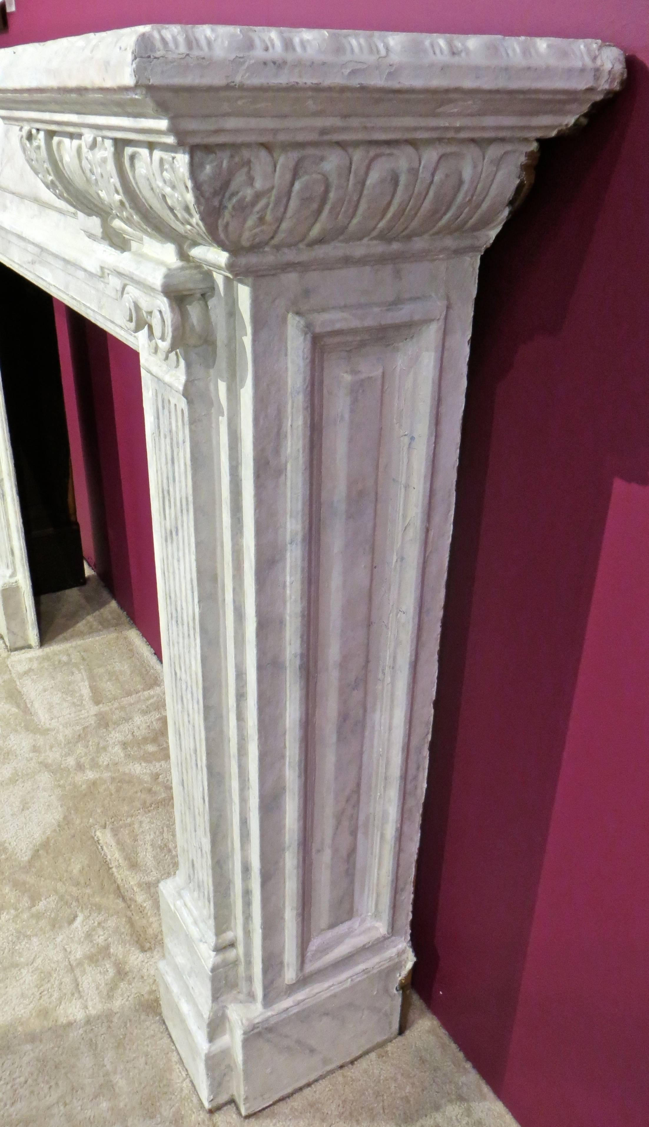 American hardwood fire surround is nicely carved, with floral decor, raised relief and a pair of fluted ionic columns on each side beneath the mantel. The finish has been 