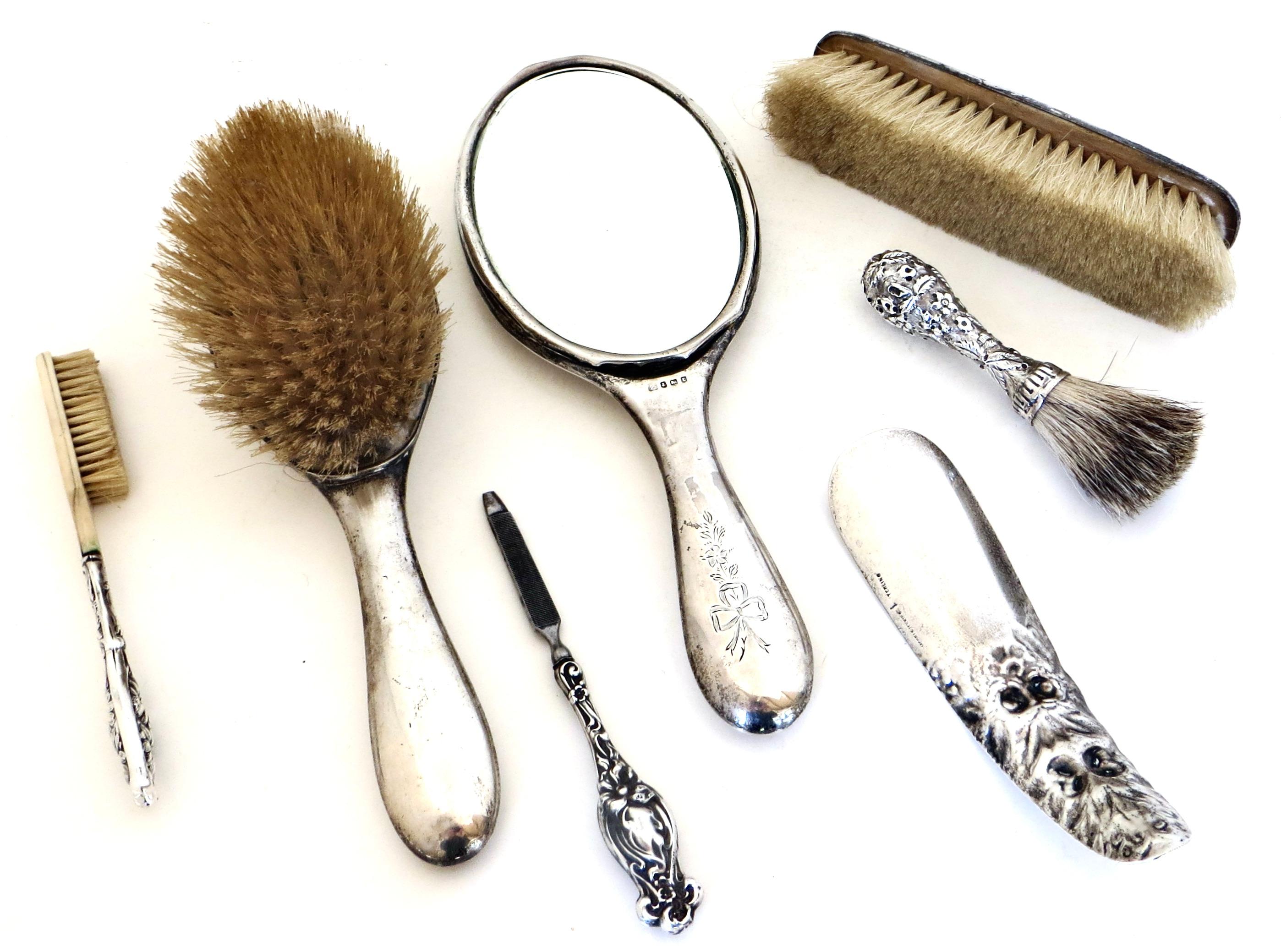 Fabulous hard to find late 19th century Art Nouveau ensemble of seven marked sterling silver vanity items to decorate and utilize for the commode; consisting of;

1) Matching hallmarked silver backed hand held mirror with beveled plated original