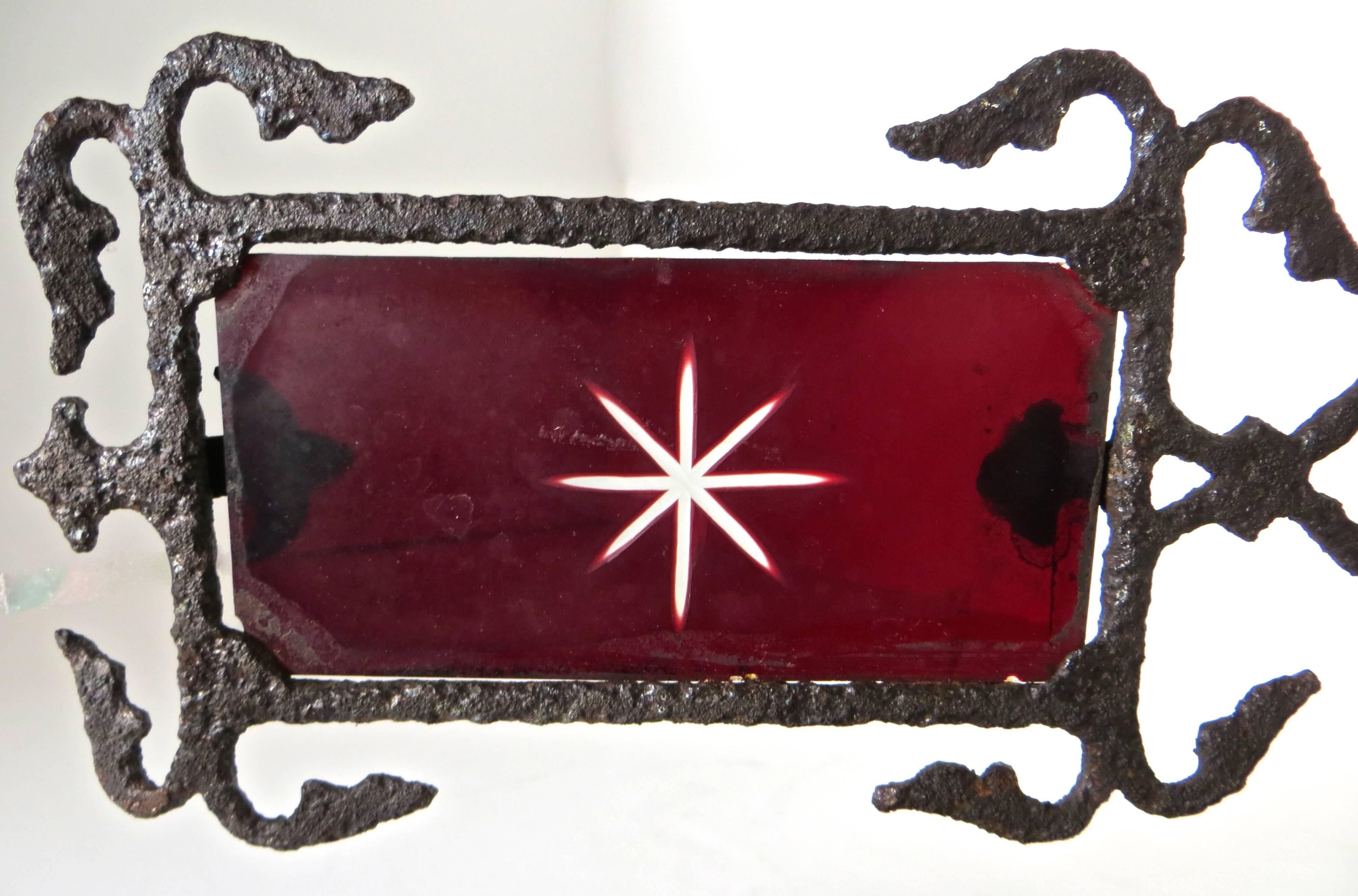 Diminutive arrow directional banner weathervane with original red glass inserted in an iron frame perimeter, with a cast iron arrow design on each corner. The red glass has a deeply etched translucent multifaceted white star pattern on both side).