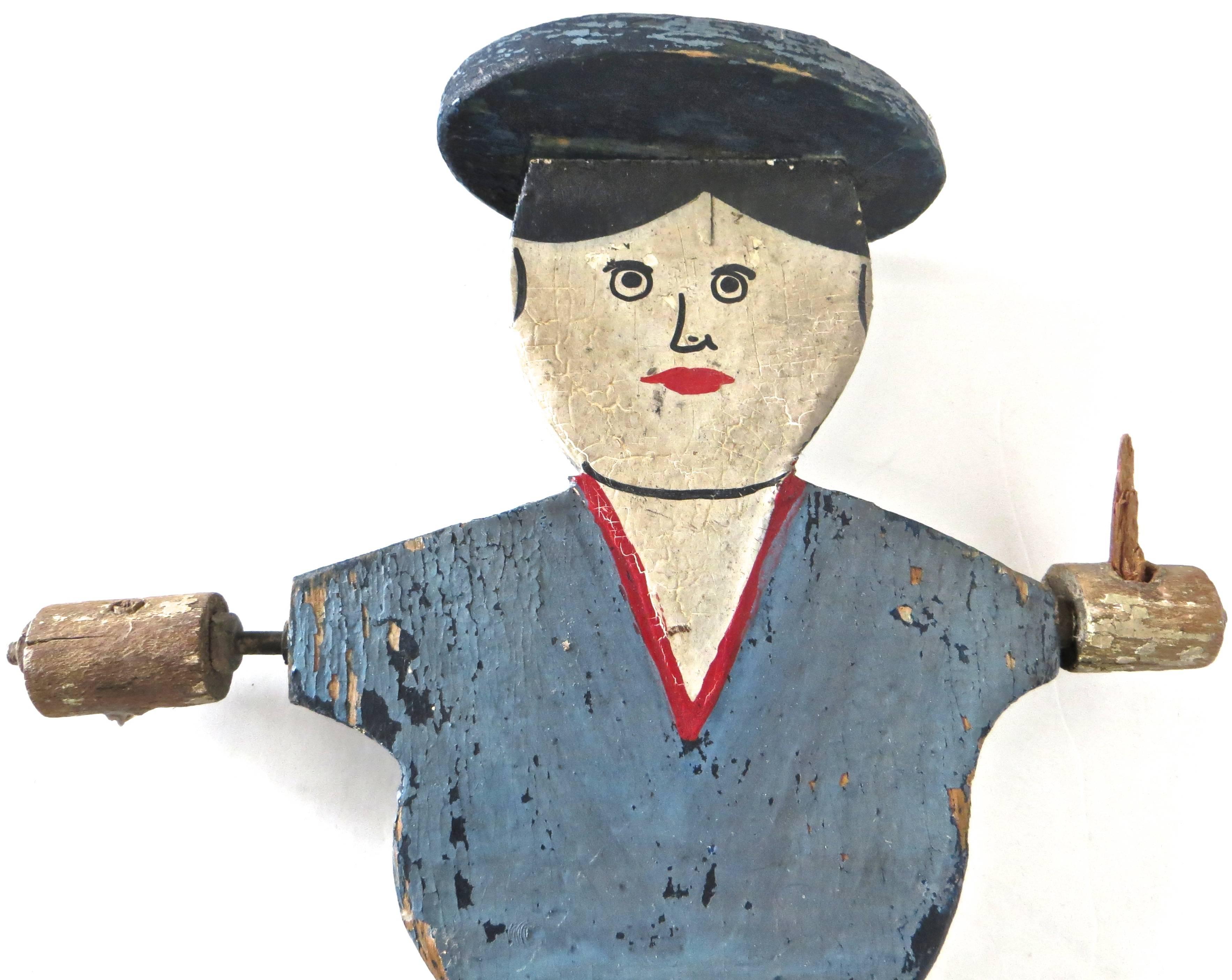 American 19th century Folk Art whirligig is hand-carved and painted, probably pine, in excellent original paint, which is obvious by noticeable period crazing. Sailor boy (lacking hand paddles which is usual) is painted in colors of red, white, and