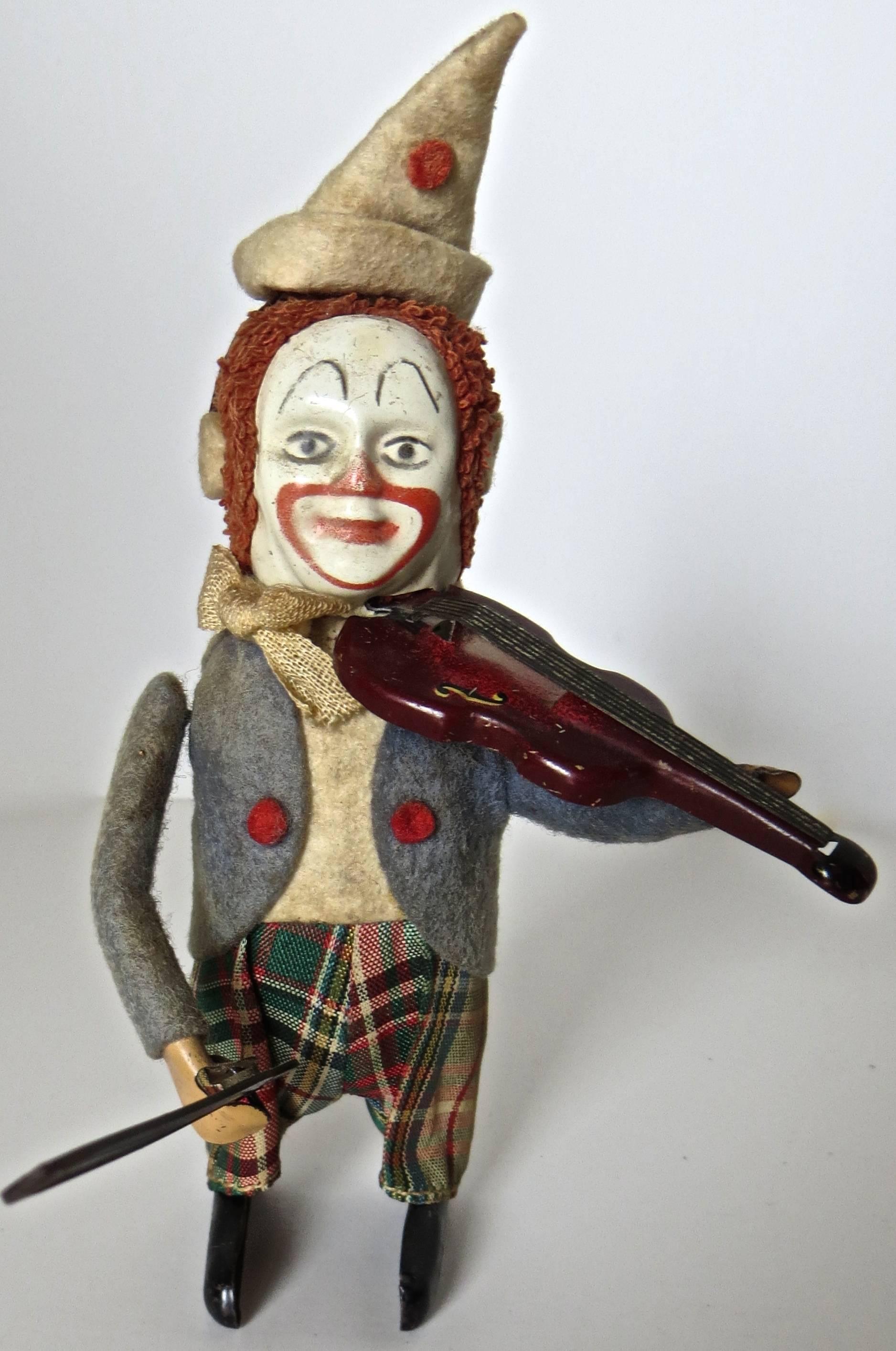 Entertaining clockwork toy that when wound up starts the clown playing his violin in a realistic motion while dancing around at the same time. Excellent condition for this toy, manufactured by the Schuco Company of Germany, circa 1940s. Hand-painted