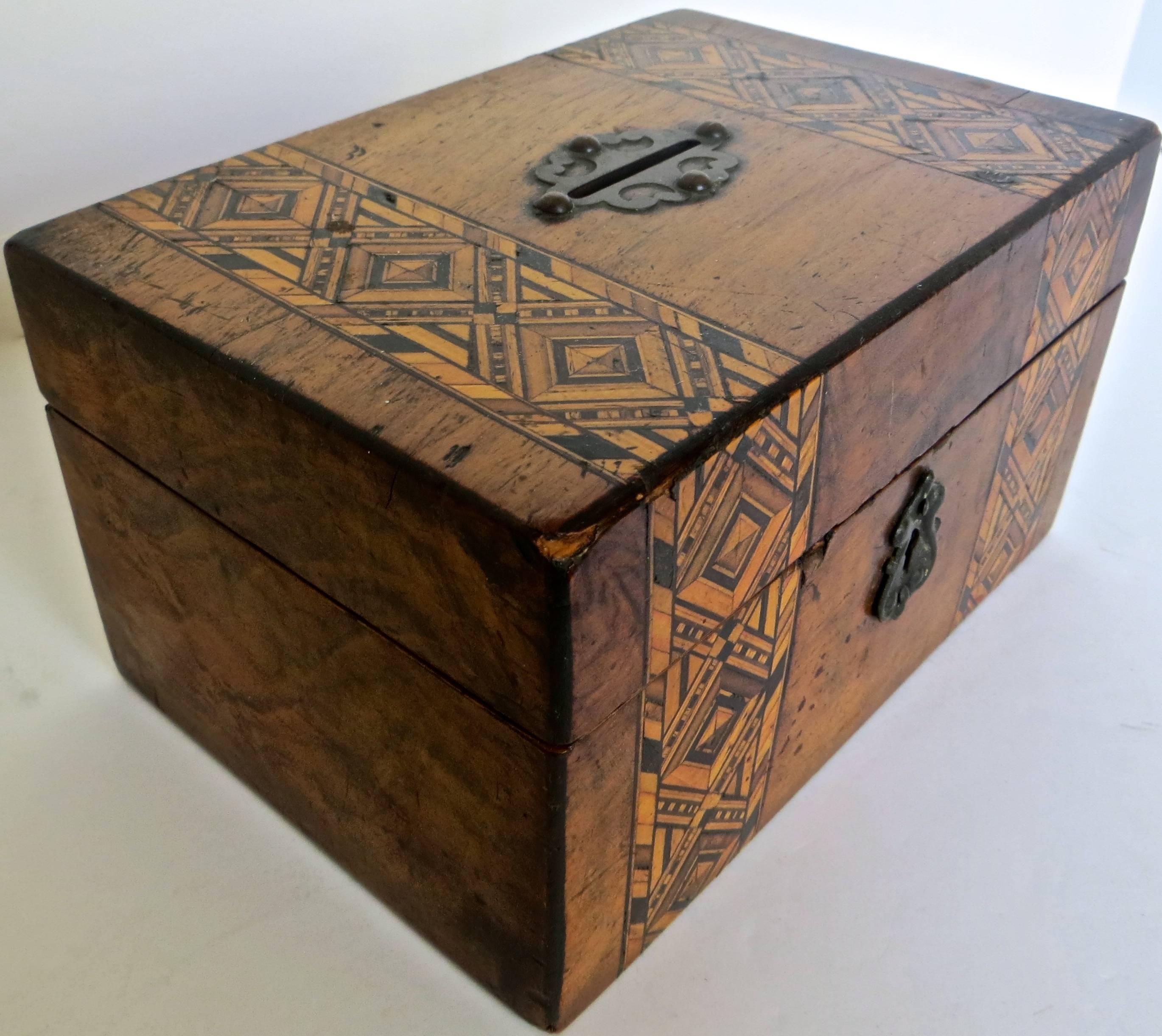 This Tunbridge box still bank is indigenous to the Tunbridge ware cottage industries of the town of Tunbridge Wells, Kent, England in the 18th and 19th century. Typically the boxes were inlaid with a multiplicity of different colored woods, cut in