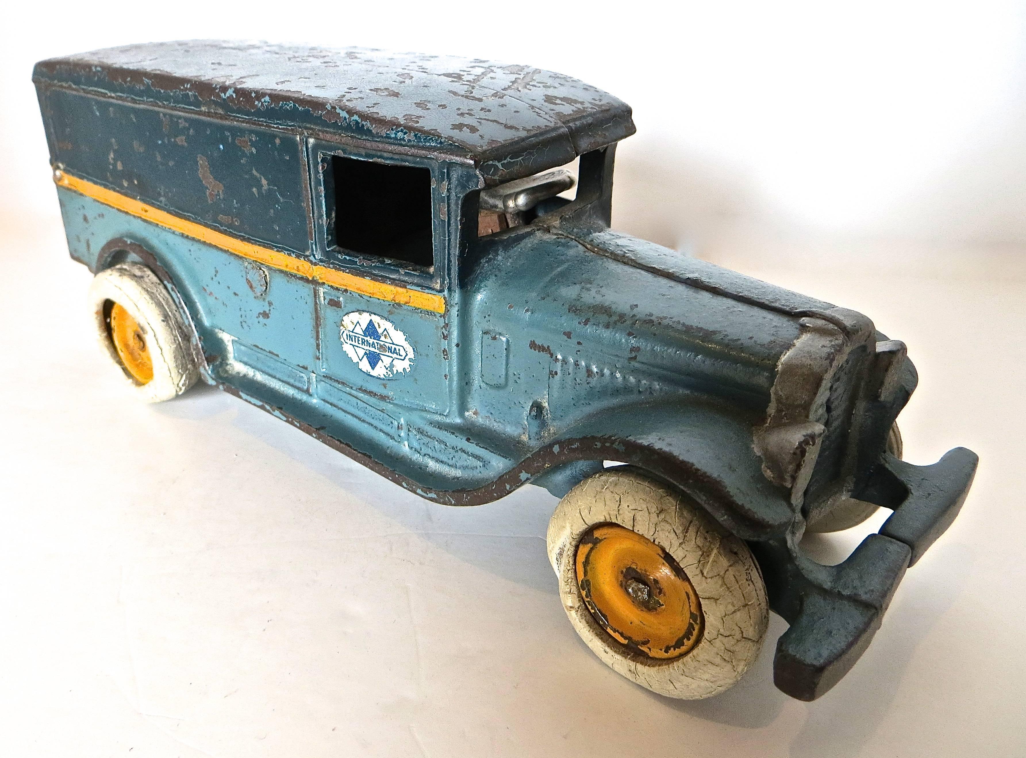 This truck was manufactured by the most prolific maker of cast iron toys during the 1920's, The Arcade Manufacturing Company in Freeport, near Chicago. 
Cast iron black and blue variation with orange stripe all around. 