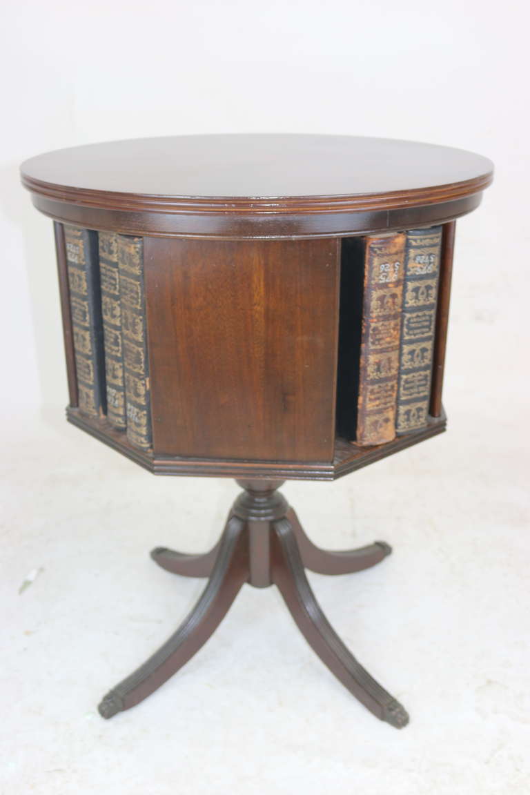 A distinctive Federal style mahogany drum table with revolving bookshelves, four solid panels and openings for books, round top with lovely flame mahogany pattern radiating from an eight point marquetry inlay star --- Duncan Phyfe style reeded splay
