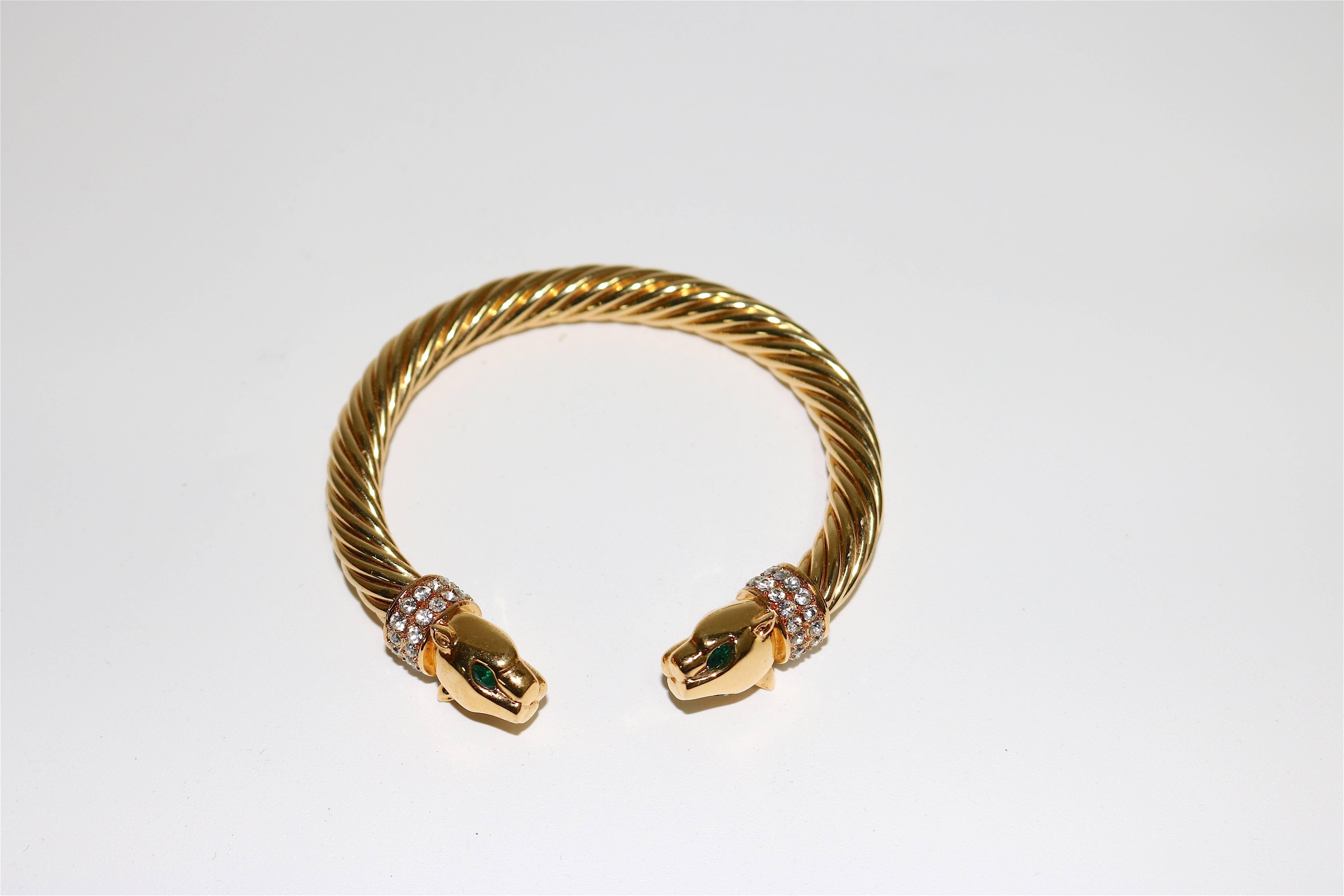 A Jackie Collins original fashion design Glam Bracelet, in the manner of Cartier's rare gold panther Torc bangle bracelet selling for $25,000. and up.
This is a lovely gold-plated Torc bangle bracelet with rhinestone collar panther head end caps and