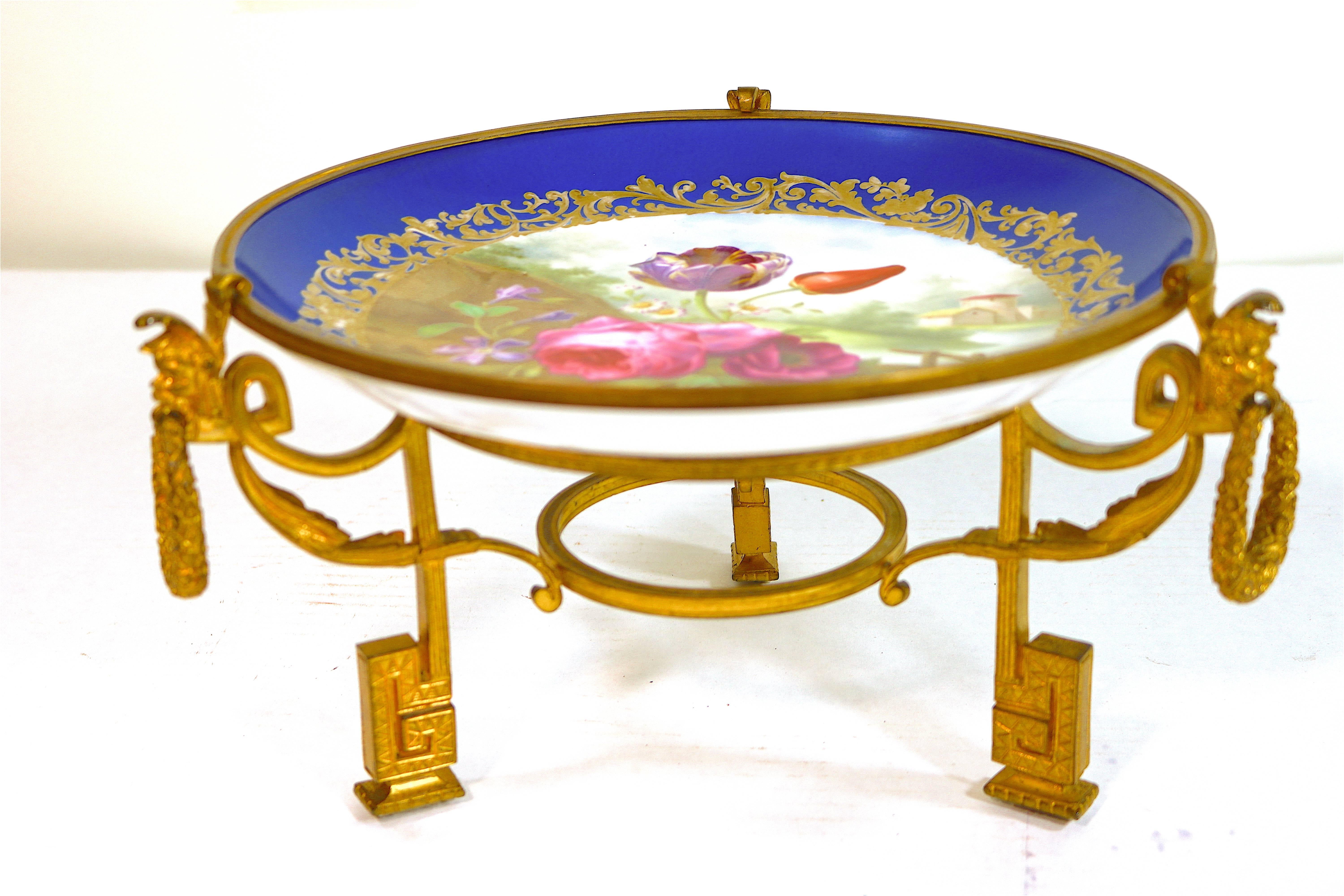 A magnificent and rare Napoleon III compote.
-Chateau des Tuileries marking- France, circa 1846. A shallow bowl with Bleu Celeste border, enclosing a gilt inner border of scrolls and flowers, enclosing a hand painted scene with a pink rose and a