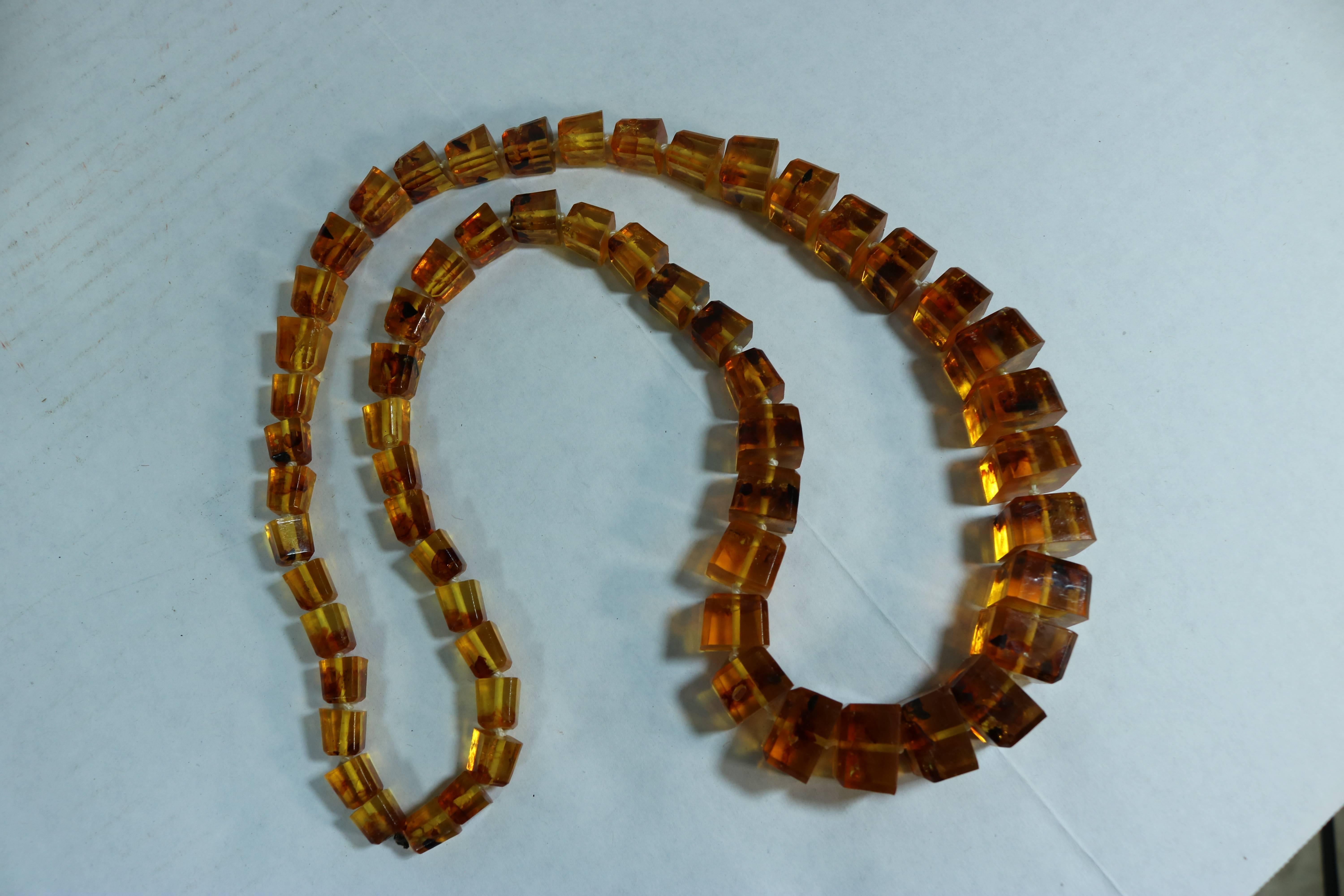 Stunning very long amber knotted necklace. This amber necklace example is a good quality piece in inclusions, clarity and overall aesthetic appeal.
Amber jewelry is currently very ‘hot’ and sought after today by fashionistas.

Measure: 15 1/2”