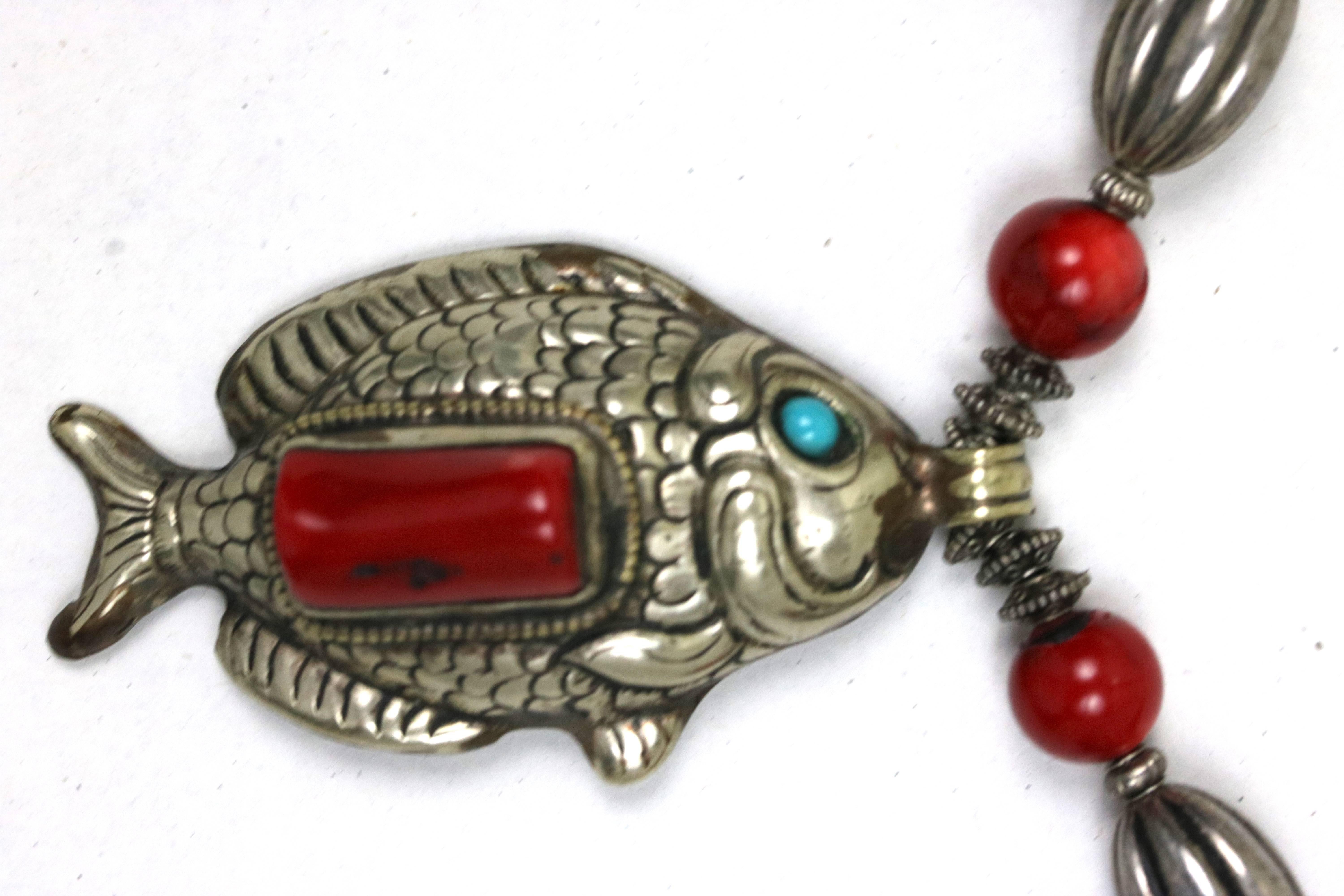 Fabulous one of a kind necklace comprising coral and turquoise beads,
sterling silver beads and end caps suspending a Tibetan repousse
Sterling silver large fish pendant with coral stone inlay-intricate back design
with double fish