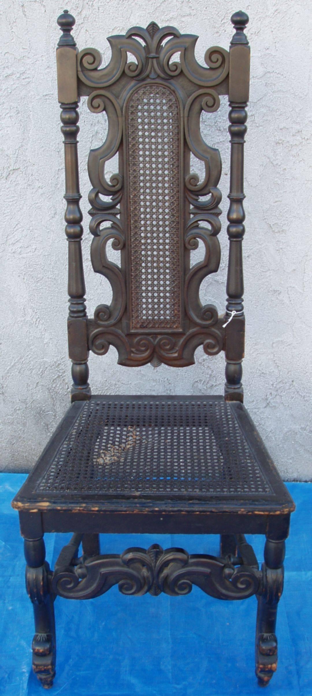 A very handsome pair of  20th century tall back side or hall chairs in 18th century William and Mary circa 1730 style. Nicely carved feather crest is repeated in the top and bottom rail. Walnut with a very dark brown slightly faded warm patina. one