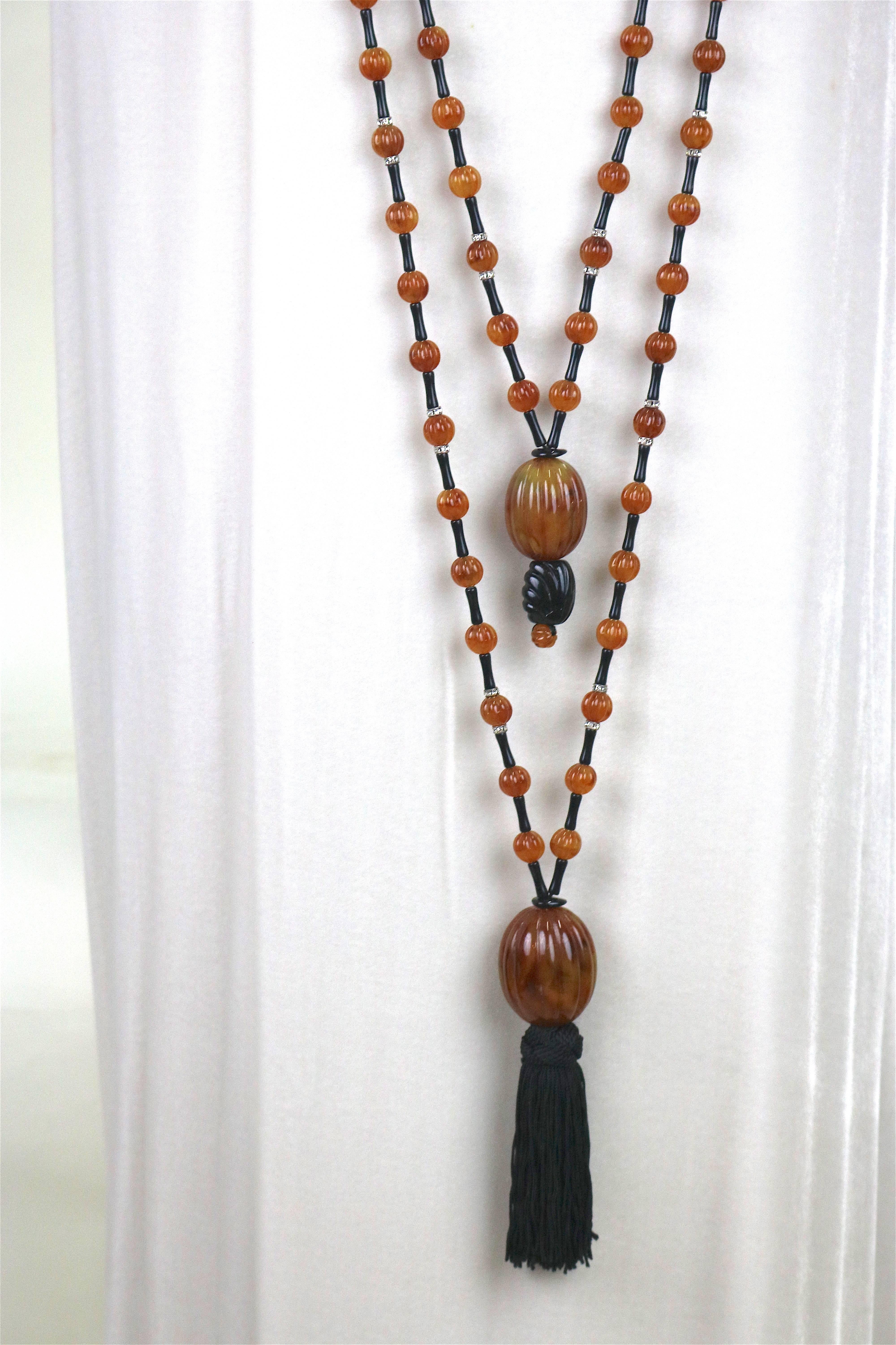 Dramatic Double Bead Necklace ending in Tassels by renowned jewelry designer Angela Caputi Of Florence Italy.
Long double strand necklace in tortoise shell color resin beads, with black resin and several cz collar spacers in the middle and a refined