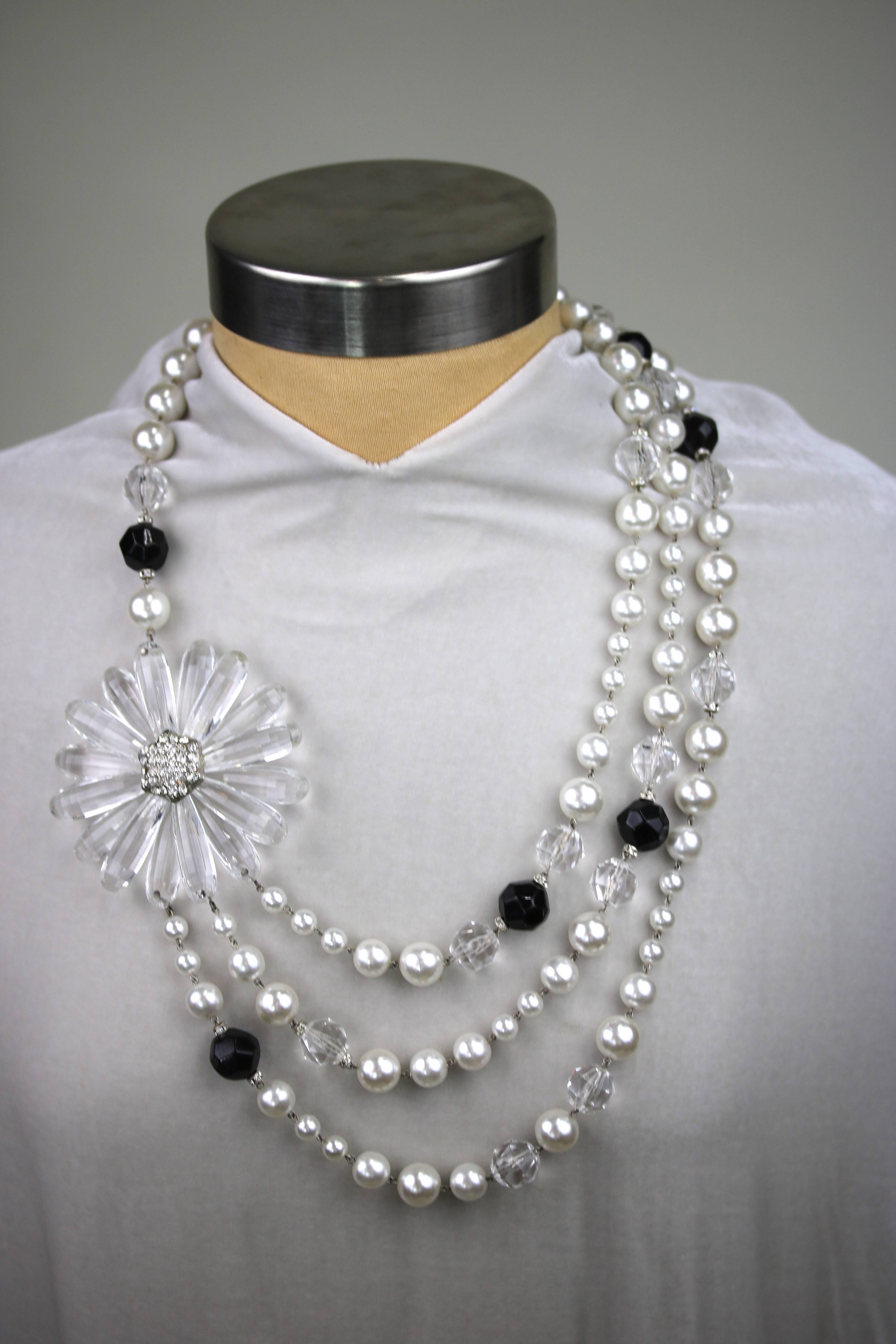 A lovely bold collar, multi strands of faux pearl, resin crystal, onyx and a large Lucite flower with czs in silver metal- Signature magnetic clasp-never worn with original Angela Caputi tag.Her production and designs are precise and very
