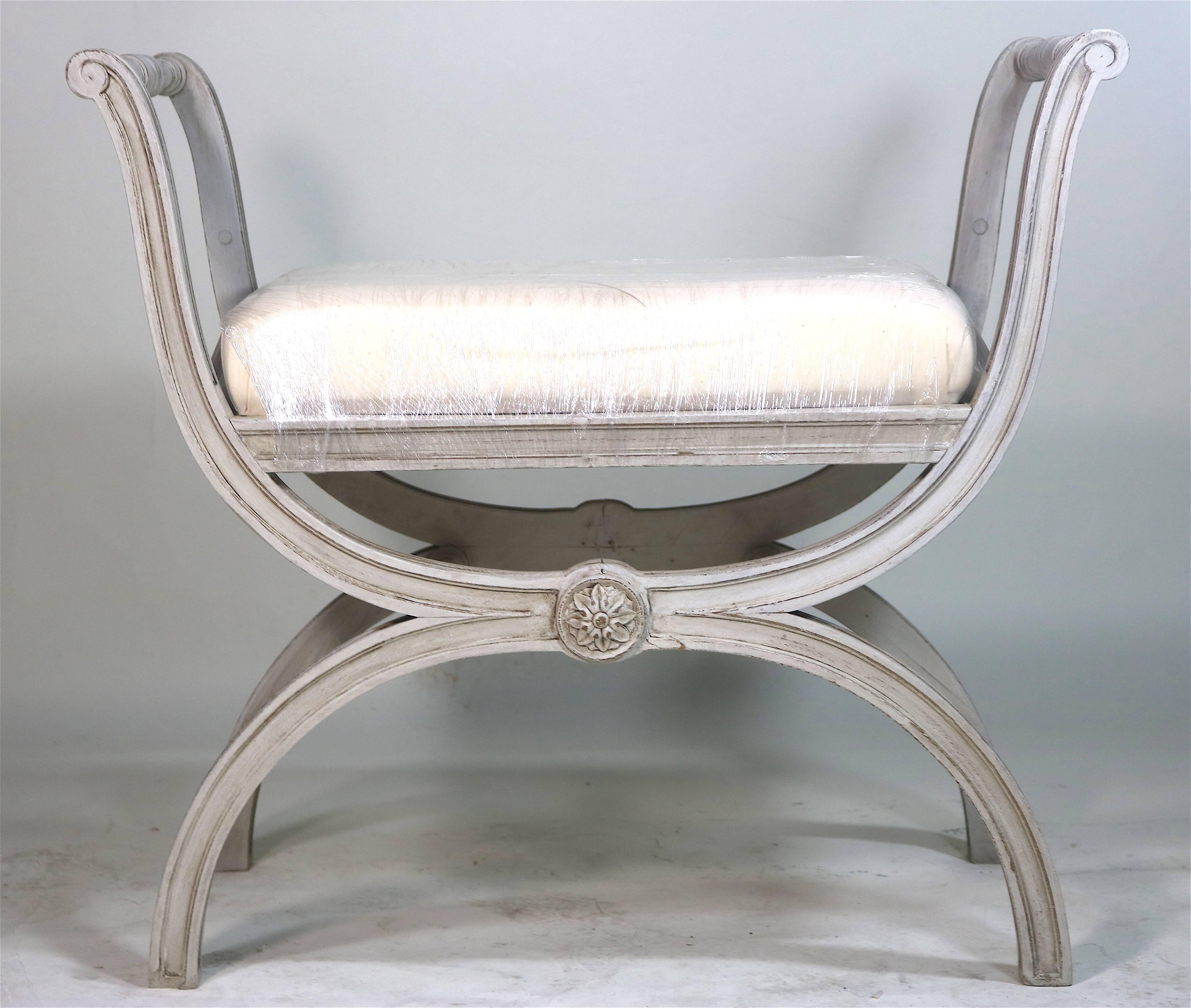 Gustavian painted Curule bench, hand-carved spindle side rails, seat rail carvings with wonderful decorative classical details, circa 1890-1900. Beautifully shaped X-base and tall side rails create a most inspired well proportioned design for your
