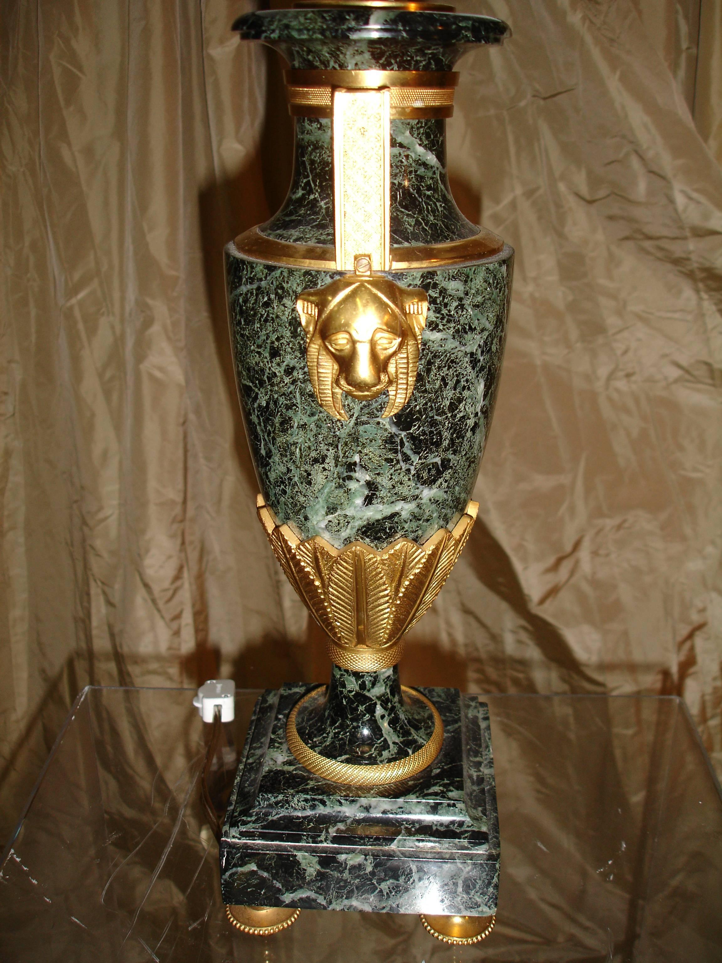 Very fine pair of refined urn shape verde marble Empire Style lamps each with elegantly waisted top with gilt ormolu detail trim--chased arms terminating in lion heads -floral leaf chased urn base and trim. Finely chased feet. Custom black glazed