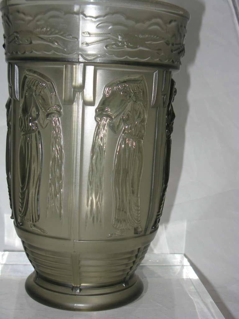 A beautiful classical highly stylized Art Deco grey smoke glass moulded vase surrounded by the Greek goddess Daniades pouring water from a vessel flying birds and clouds surround the top rim, all in molded full relief this is a beautifully designed