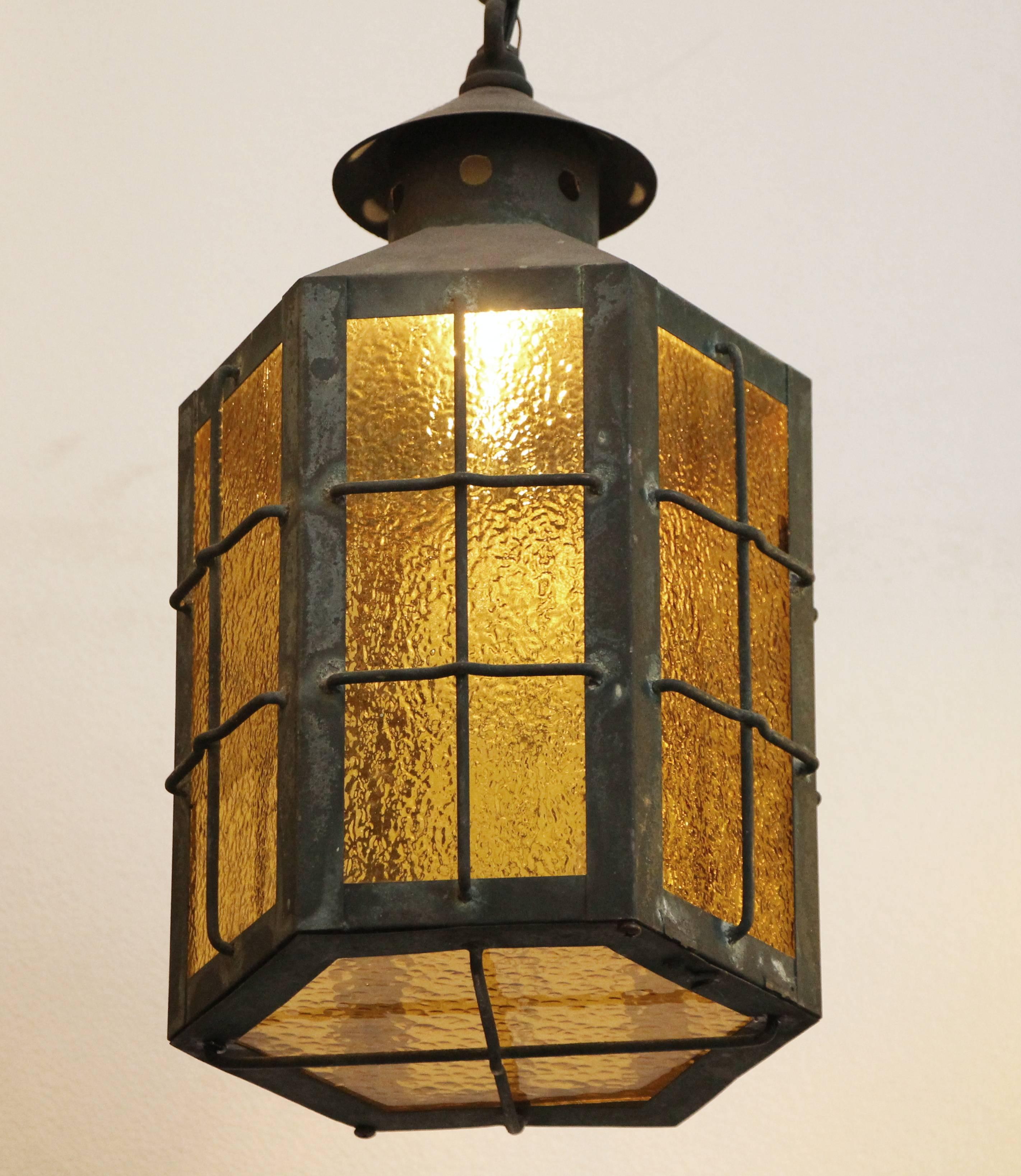 1930s pair of outdoor copper pendant lanterns with textured amber glass. There is a small raised cage on all four sides for a nice effect. These can be viewed at our 5 East 16th Street Manhattan location.