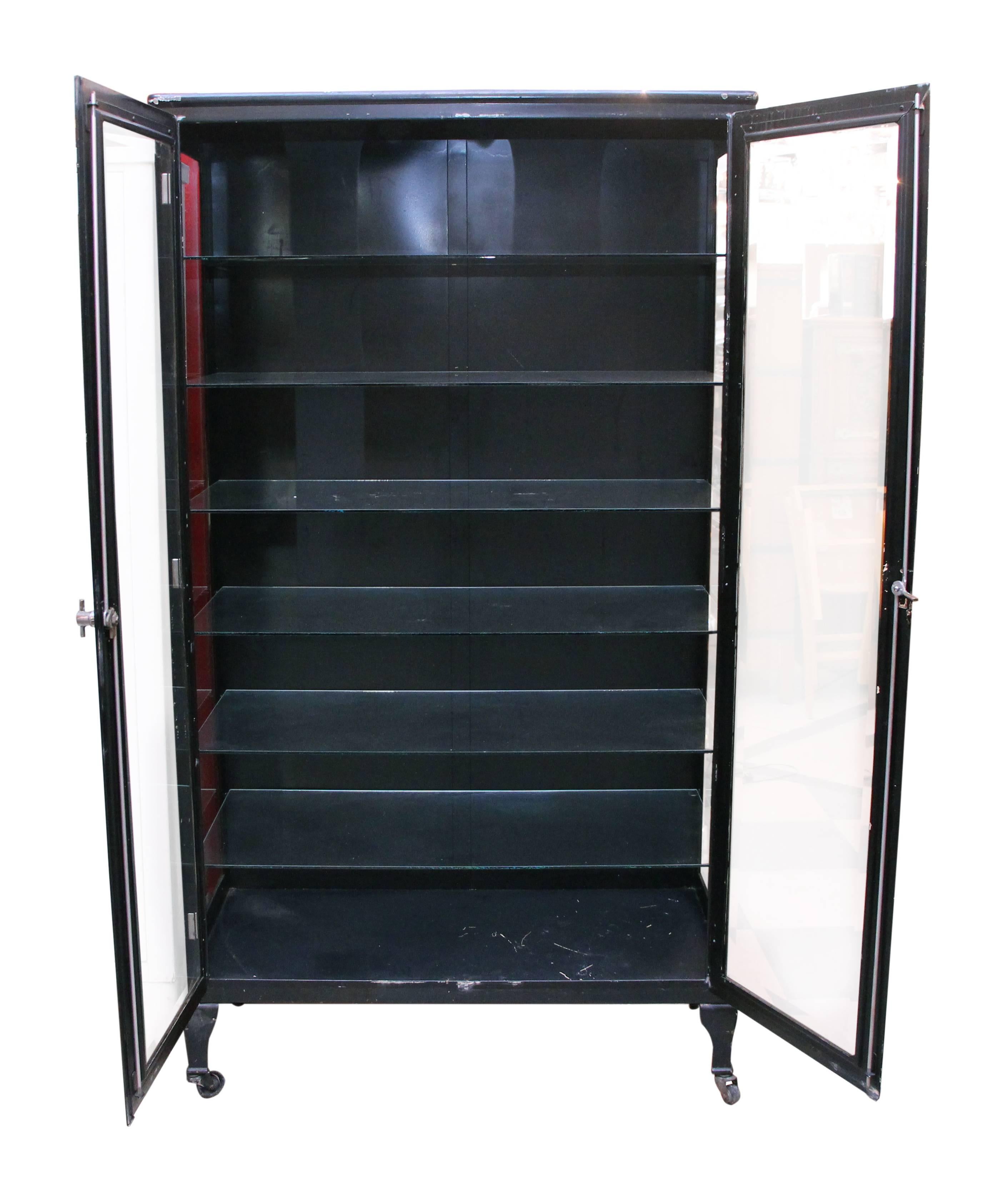 1920s vintage black medical cabinet with glass shelves and beveled glass doors. This item can be viewed at our 5 East 16th St, Union Square location in Manhattan.