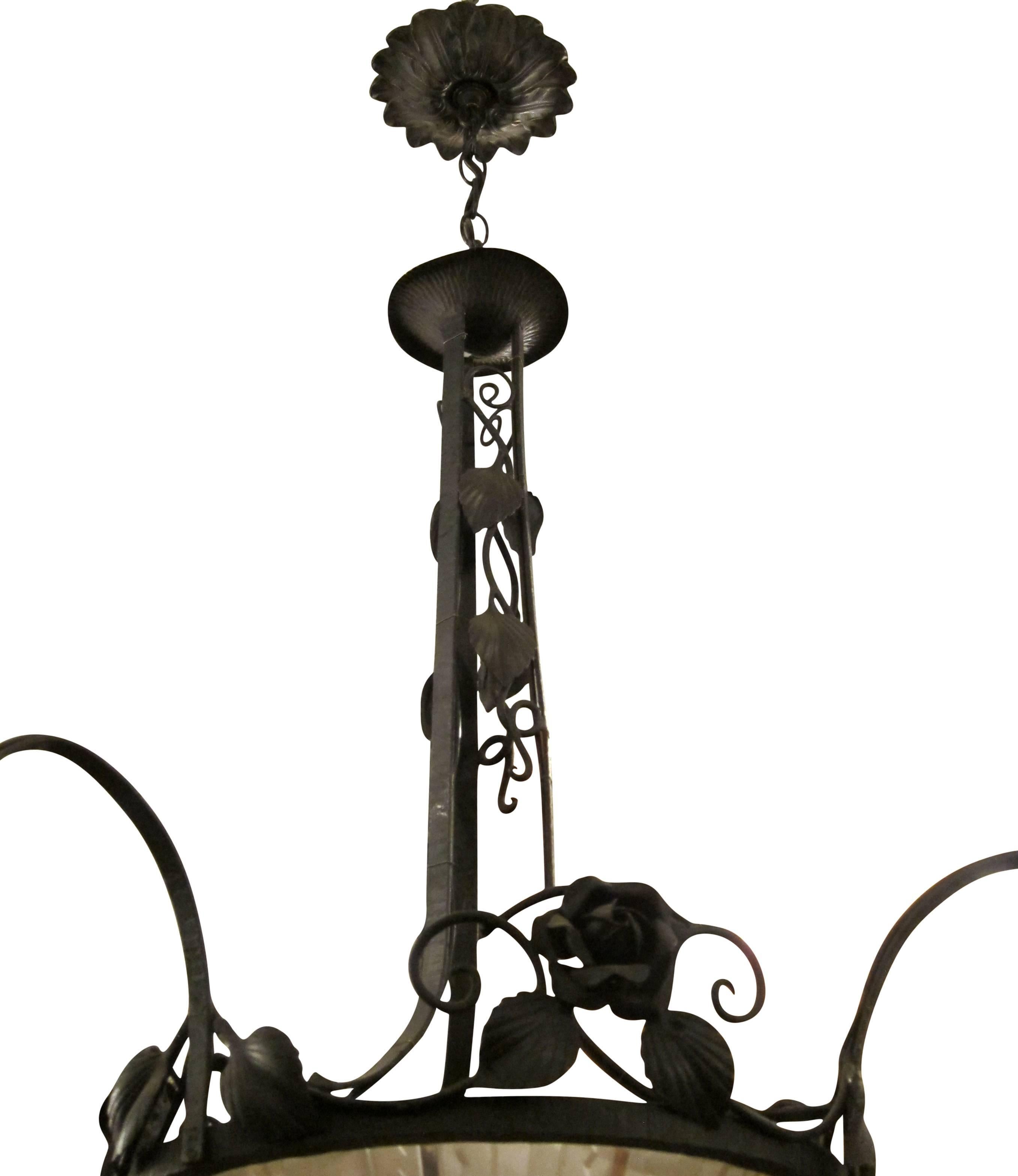 Ornate hand worked wrought iron chandelier. Features three down lights and a lit up glass bowl. Uses standard E26 lightbulbs. This can be seen at our 400 Gilligan St location in Scranton, PA.
