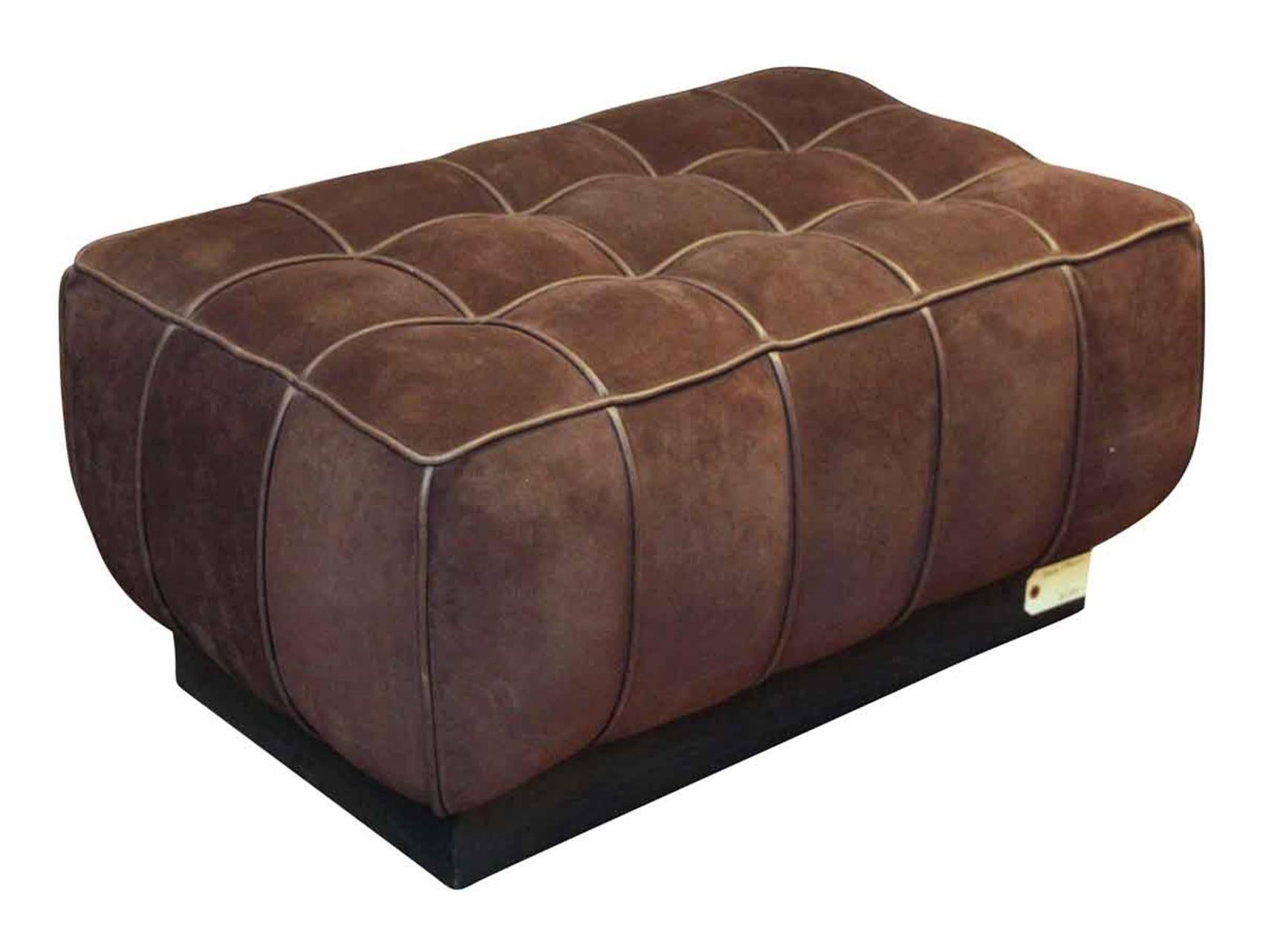 Warm brown suede ottoman with a wooden base and a leather handle feature on the backside. In excellent condition. From the 1990s. This can be seen at our 5 East 16th St, Union Square location in Manhattan.