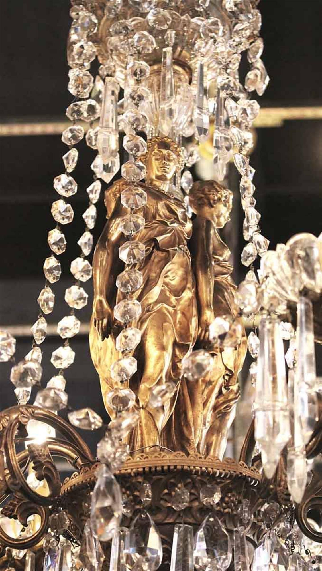 1930s, Empire style bronze and crystal figural six-arm chandelier with three maidens. This can be seen at our 2420 Broadway location on the upper west side in Manhattan.