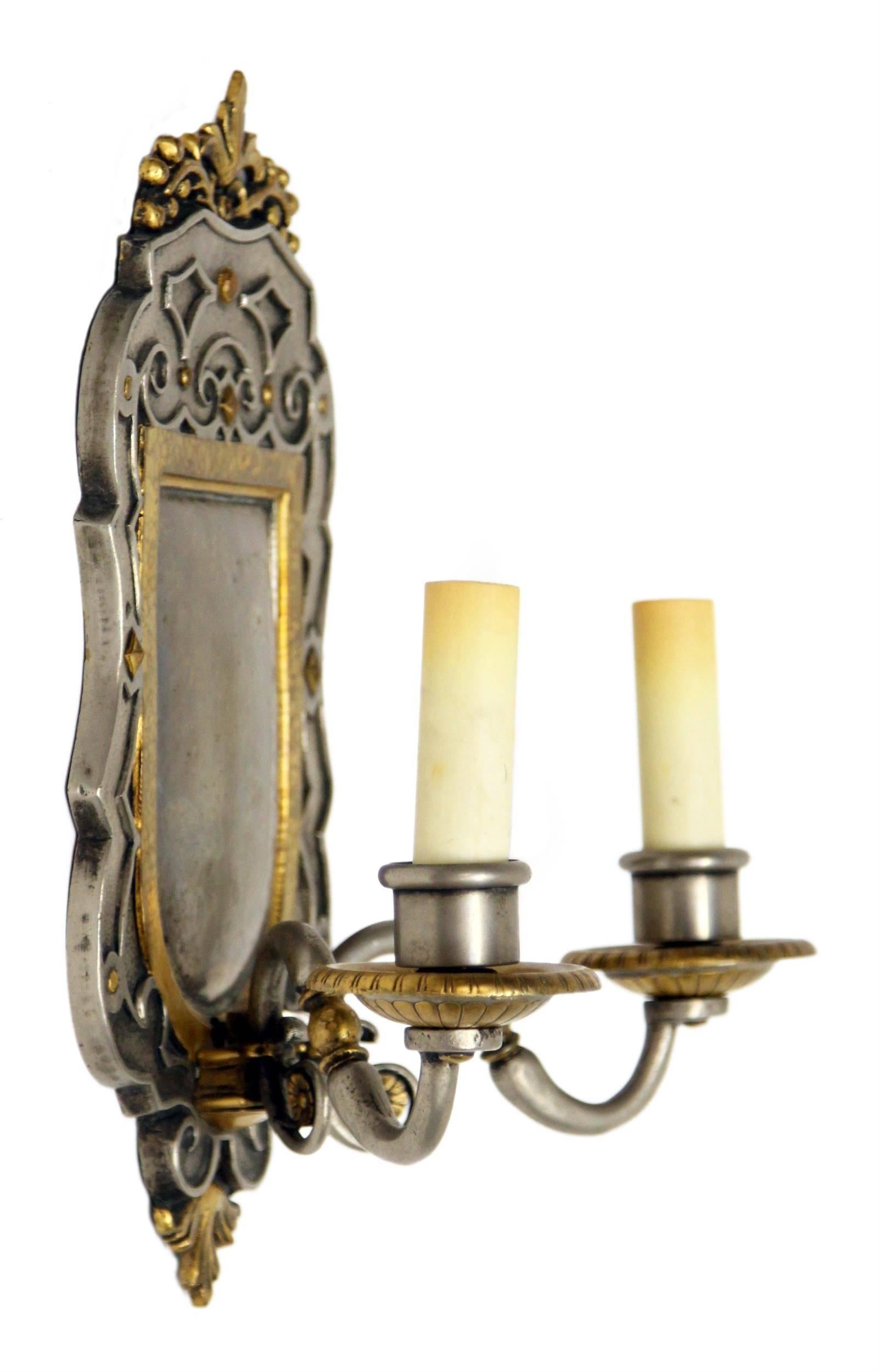 1900s pair of gilt and pewter two-arm bronze EF Caldwell sconces. This can be seen at our 2420 Broadway location on the upper west side in Manhattan.