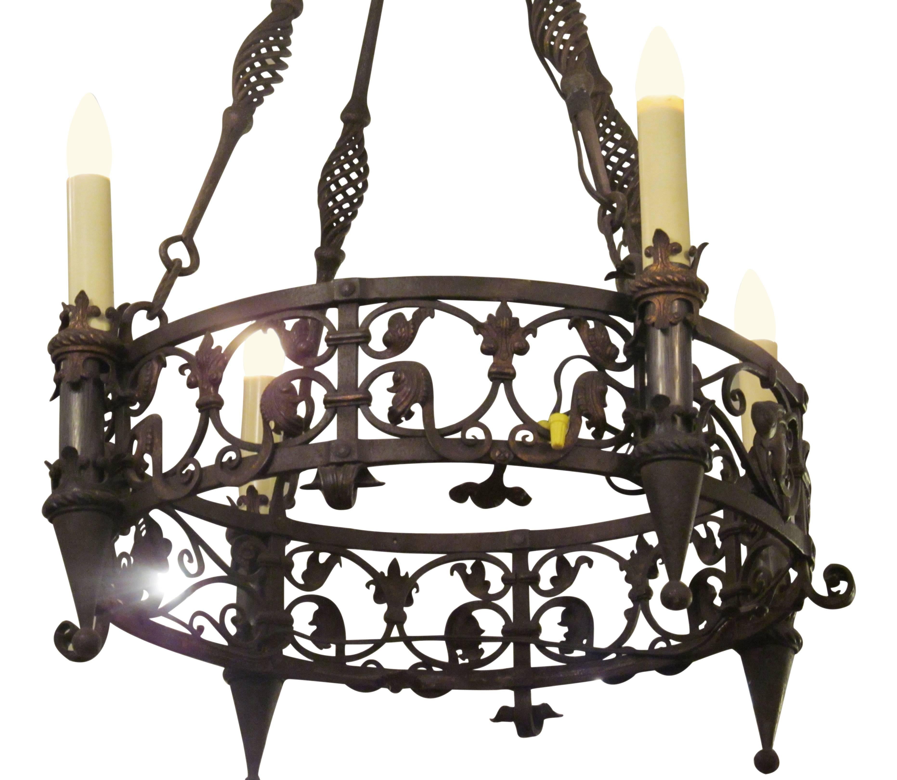 1920s wrought iron four-light chandelier with spirals and hand tooled designs. This can be seen at our 2420 Broadway location on the upper west side in Manhattan.