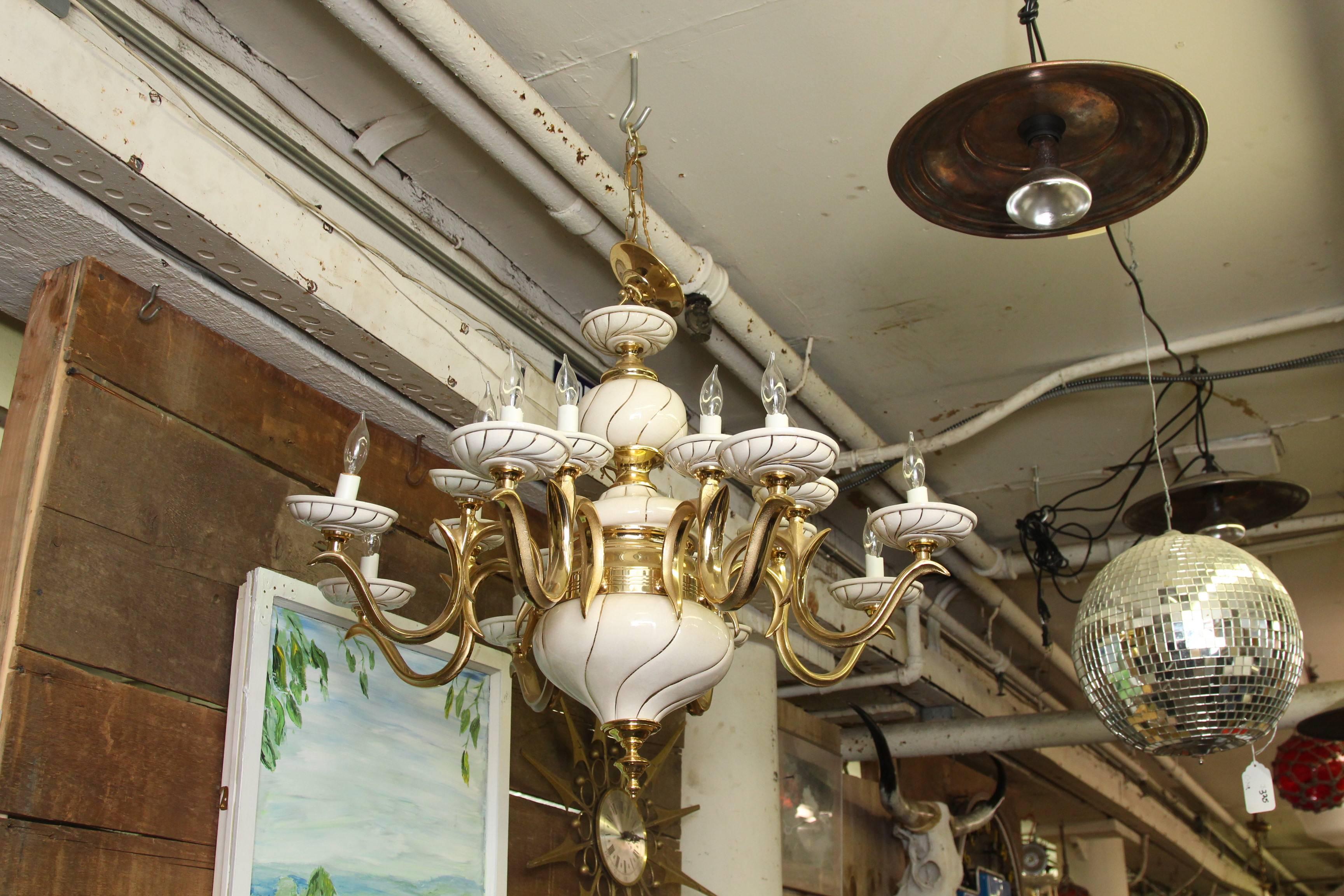 1960s Italian white porcelain and brass sixteen-light eight-arm chandelier. Beefy yet elegant brass chandelier with porcelain bobeches and centrepieces. This item can be viewed at our 400 Gilligan location in Scranton, PA.