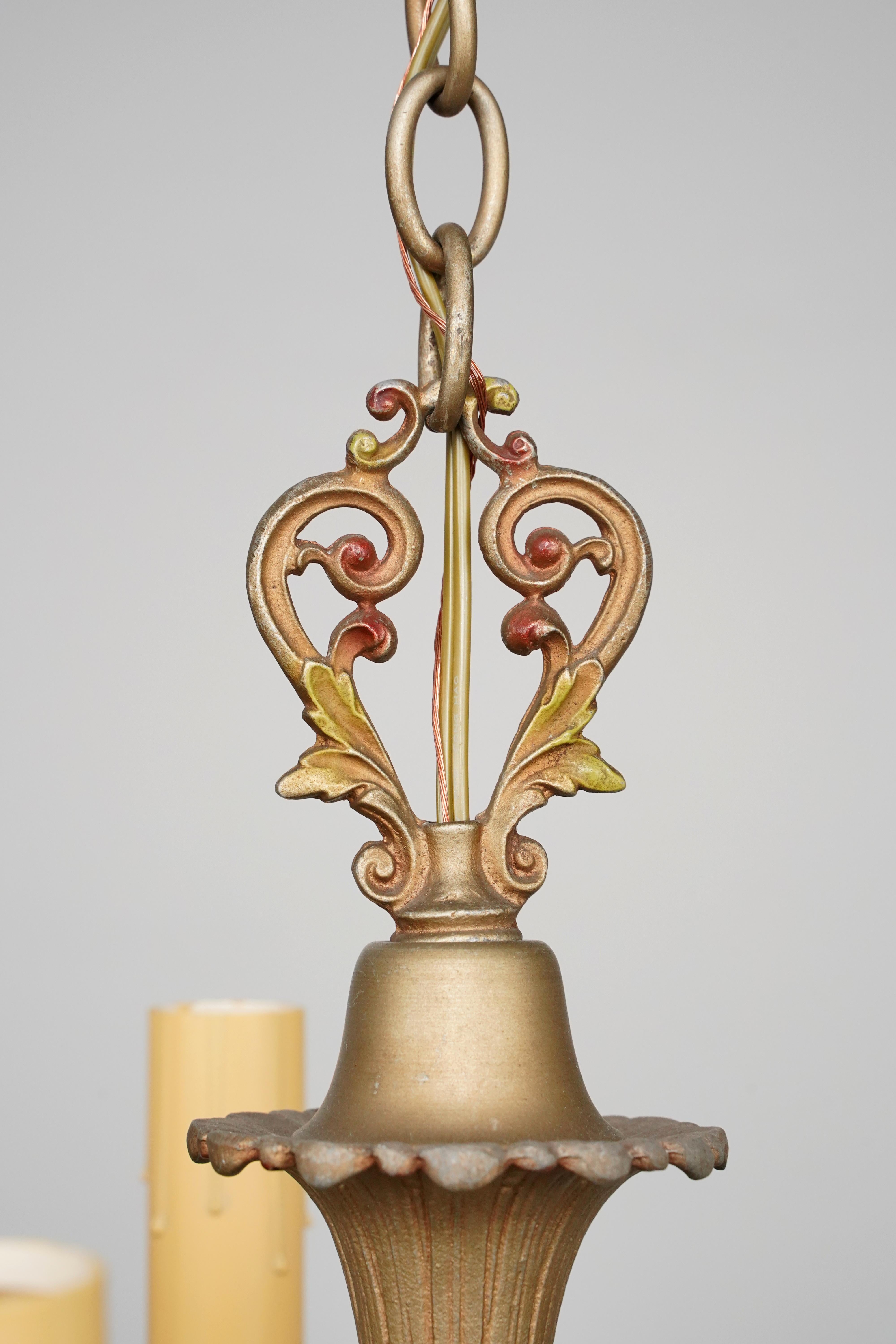 Ornate chandelier with five arms. There are faded red and green floral accents. This requires five standard Edison style medium base bulbs. This light is cleaned and restored and ready to ship. Good condition with appropriate wear from age. One
