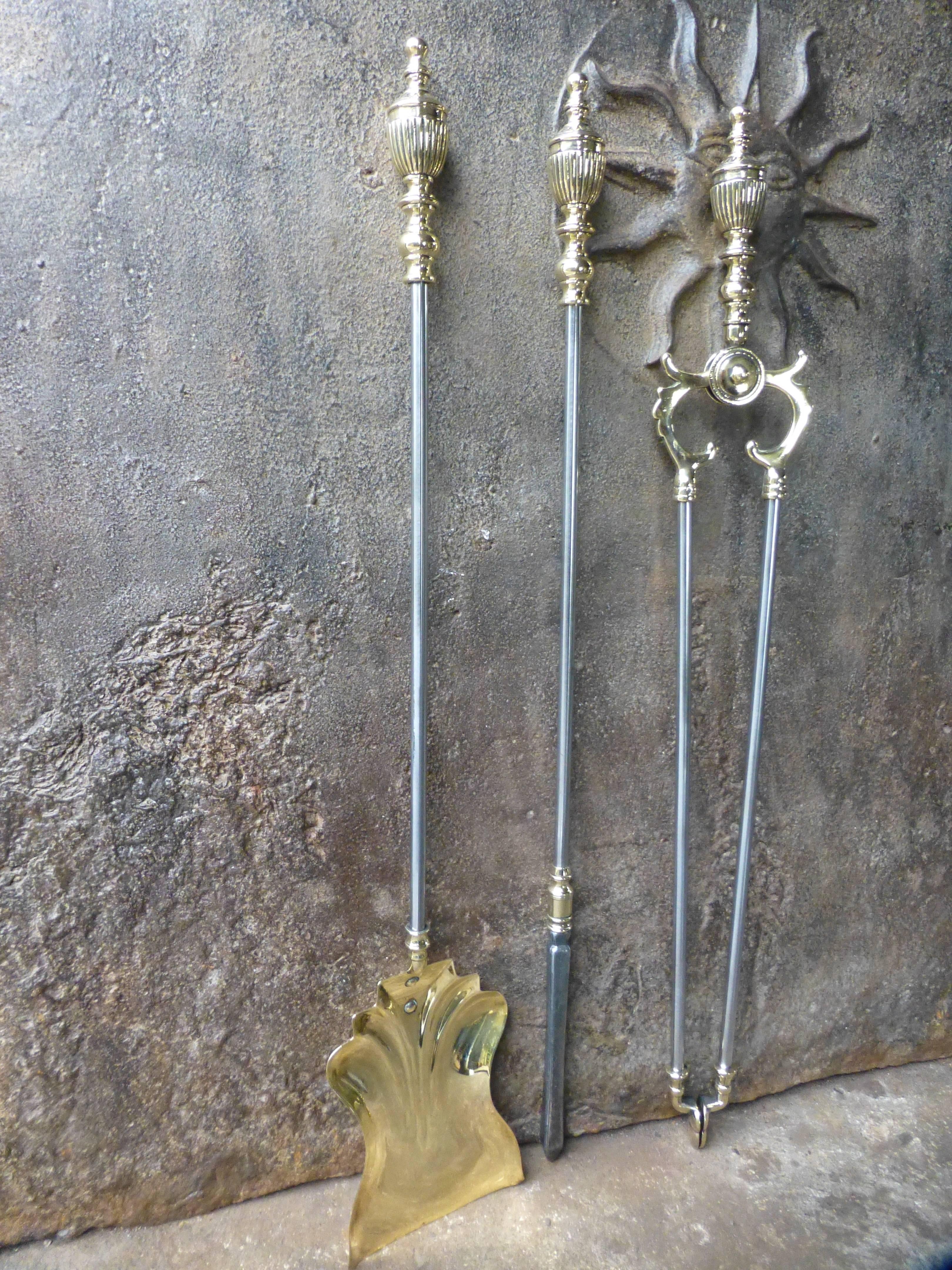 19th century English fireplace tools - fire irons made of polished steel with brass handles and other details. Victorian period. The fireplace toolset is in a good condition.

