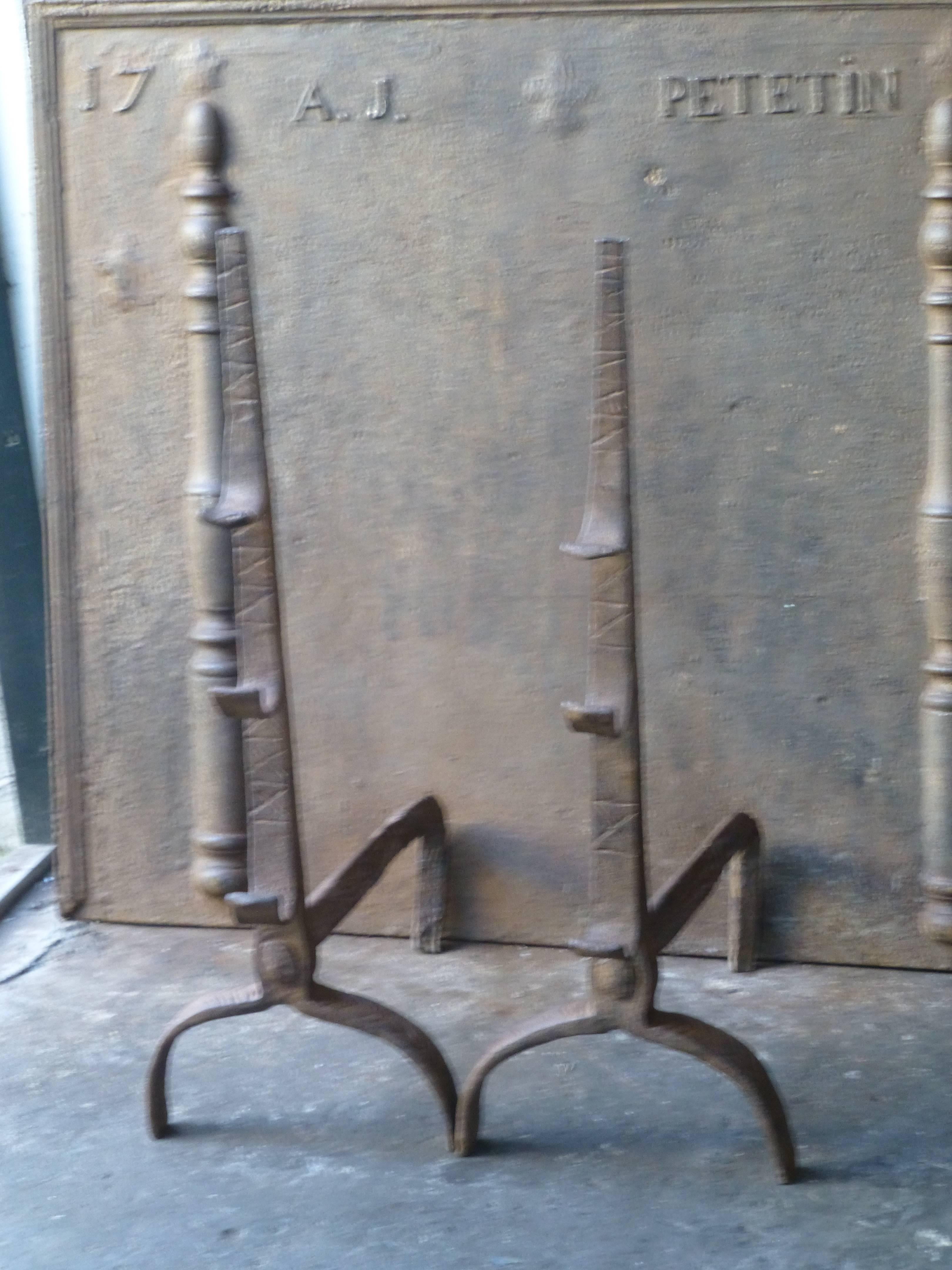 17th century French Gothic fire dogs with spit hooks. Made of wrought iron. These French andirons are called 'landiers' in France. This dates from the times the andirons were the main cooking equipment in the house. They had spit hooks to grill meat