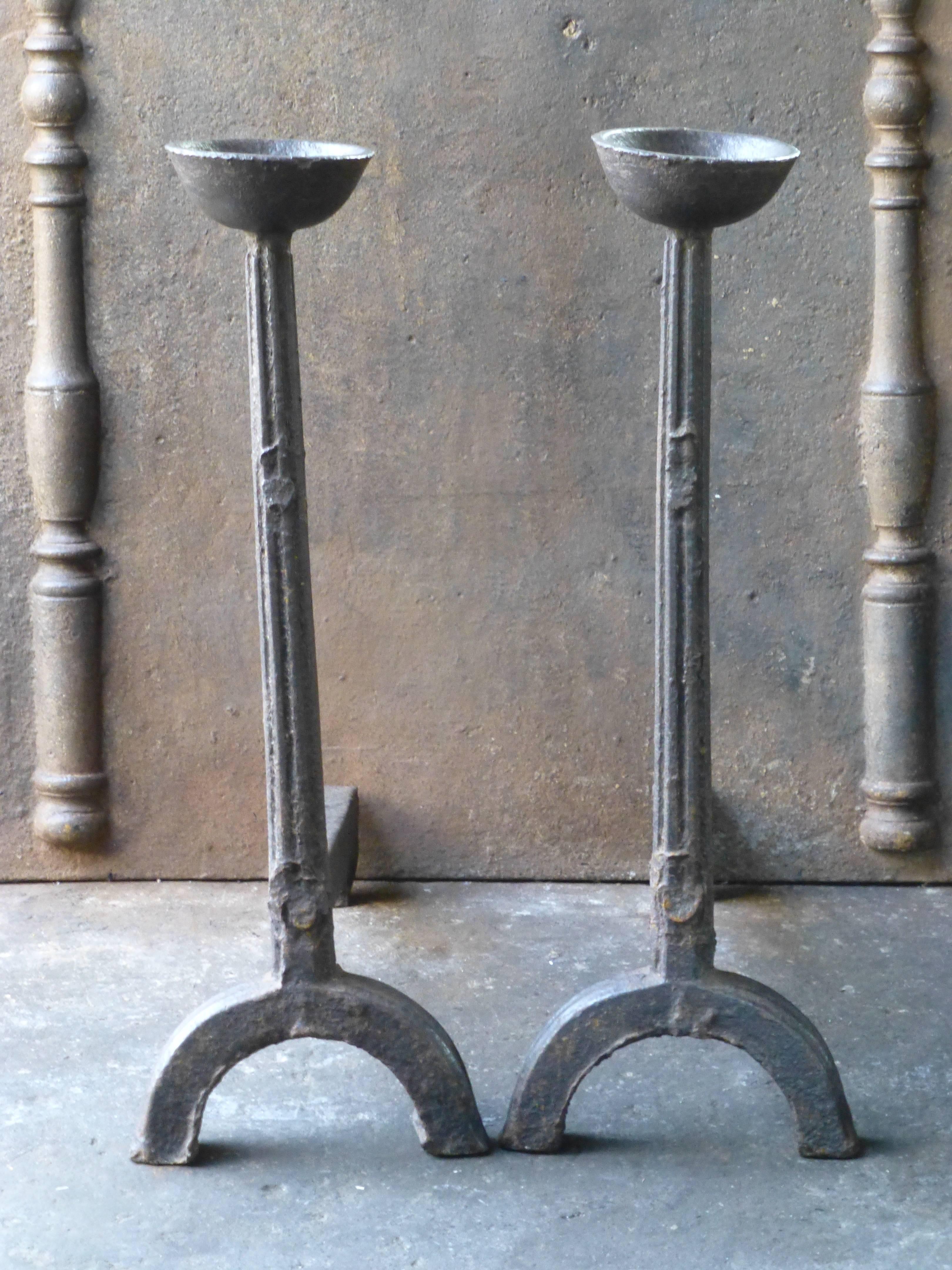 17th century andirons made of cast iron. These French andirons are called 'landiers' in France. This dates from the times the andirons were the main cooking equipment in the house. They had spit hooks to grill meat or poultry and sometimes a cup to