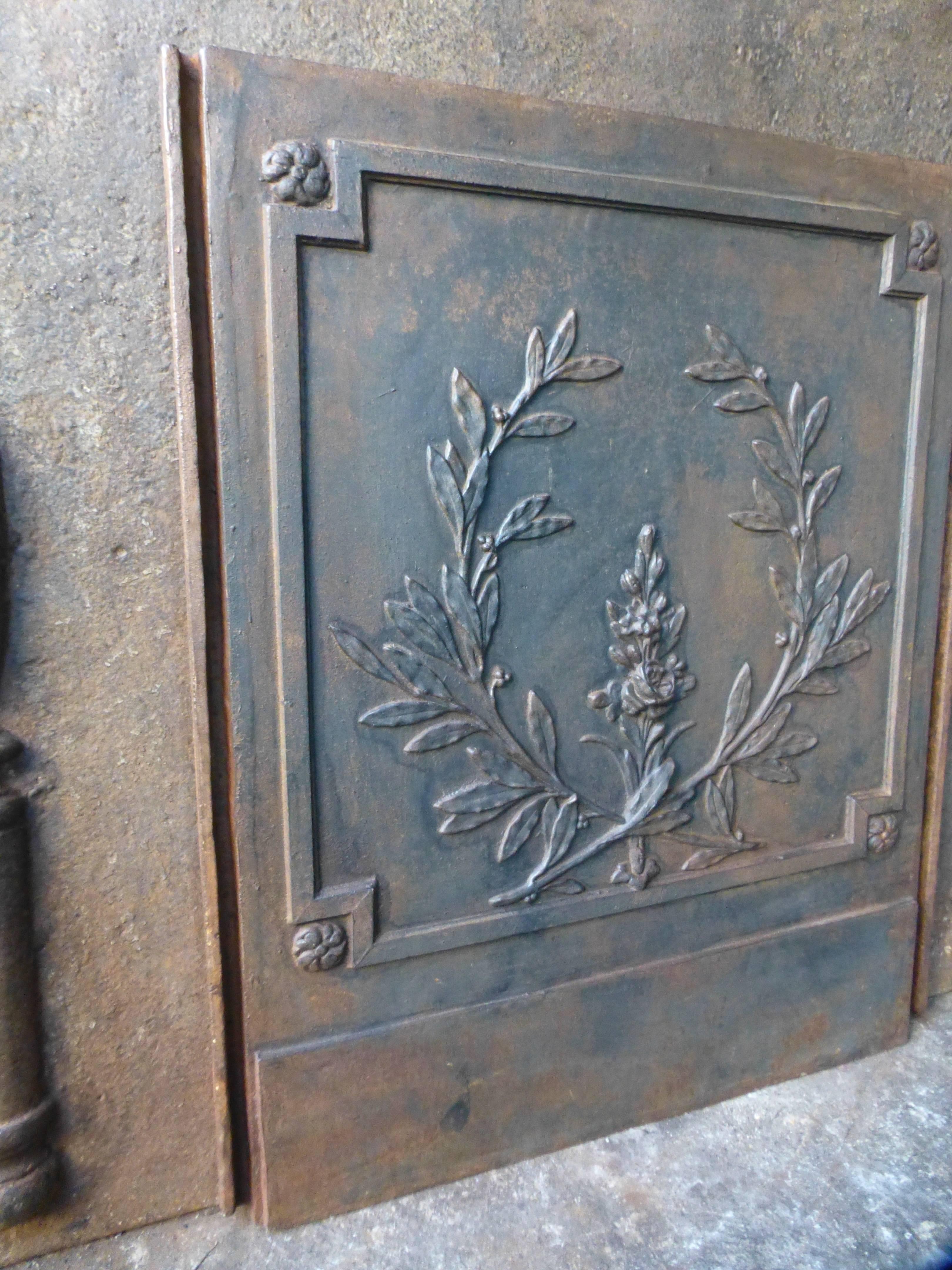 French fireback with olive branches (symbol for victory or peace) and a flower.