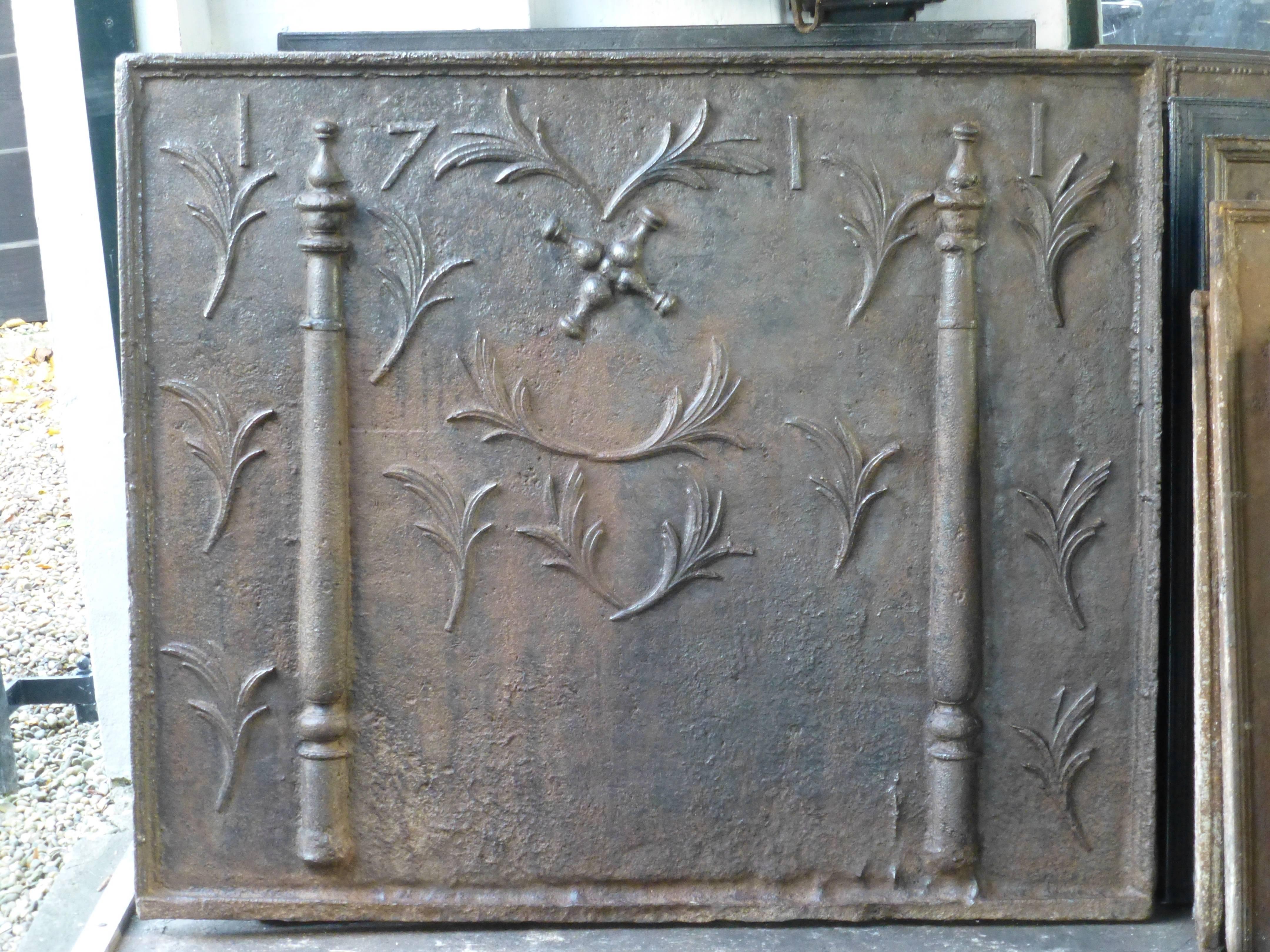 18th century French fireback with pillars, Saint Adrew's Cross, leaves and the date of production 1711.