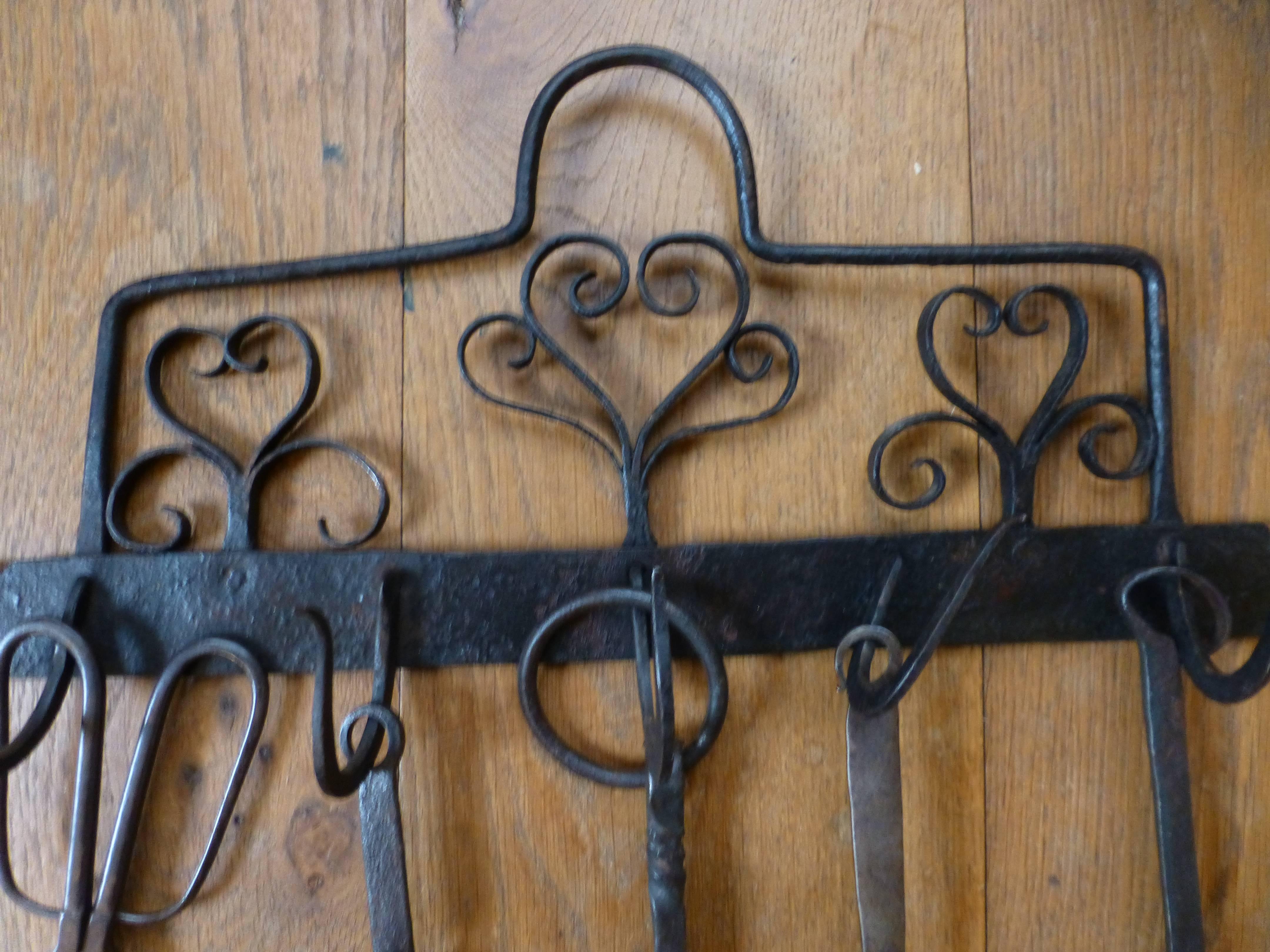 Set of 18th-19th century fireplace tools used for tasting and turning food that is cooked on an open fire. The hanger and the five tools are made of wrought iron.

We have a unique and specialized collection of antique and used fireplace accessories