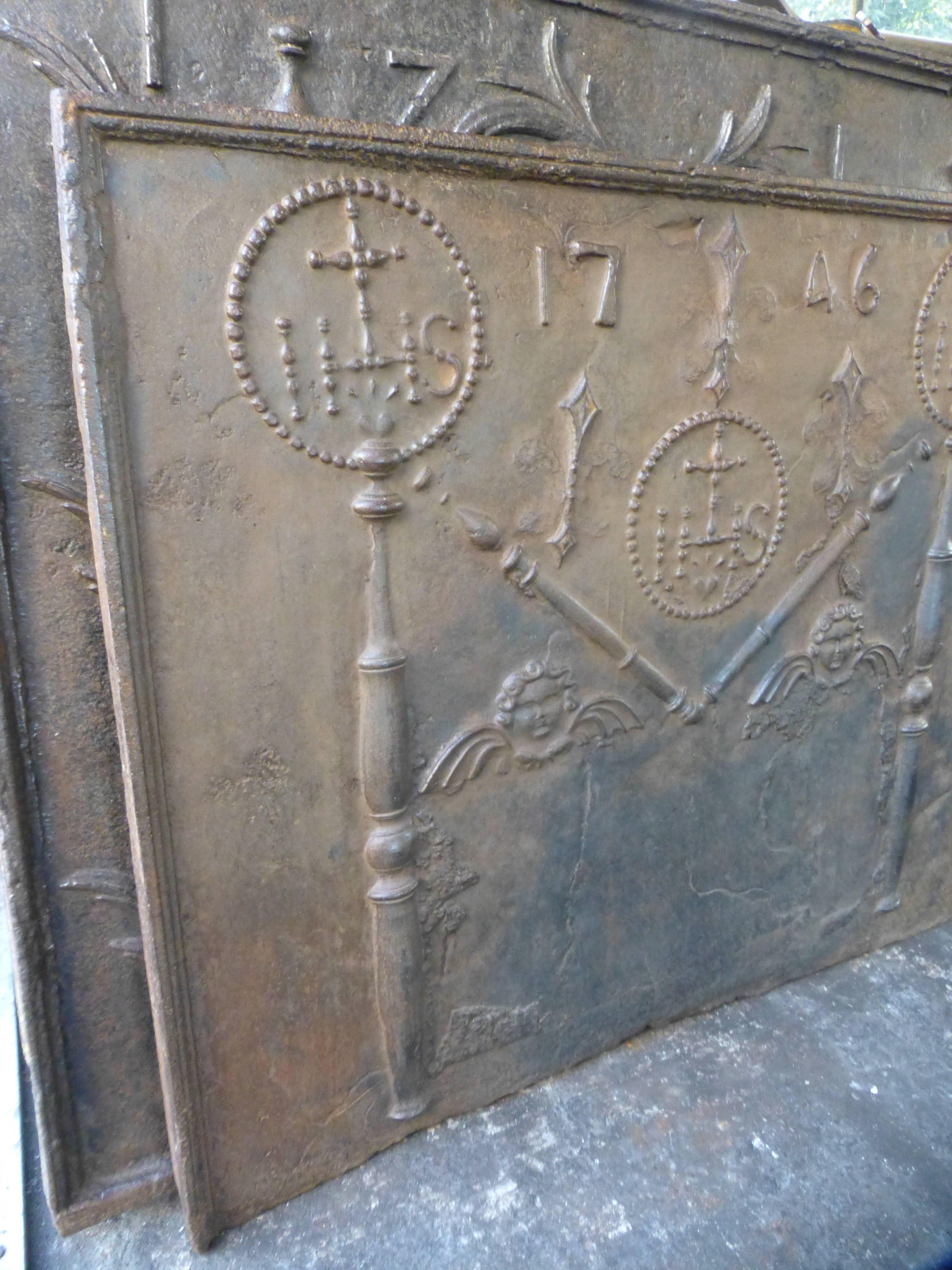 French Fireback with pillars, angels, fleurs de lis and the date of production 1746.

The monogram IHS stands for Iesus Hominum Salvator (Jezus the Savior of Humanity) or In Hoc Signo (In this sign will you win). The fleurs de lis were partly