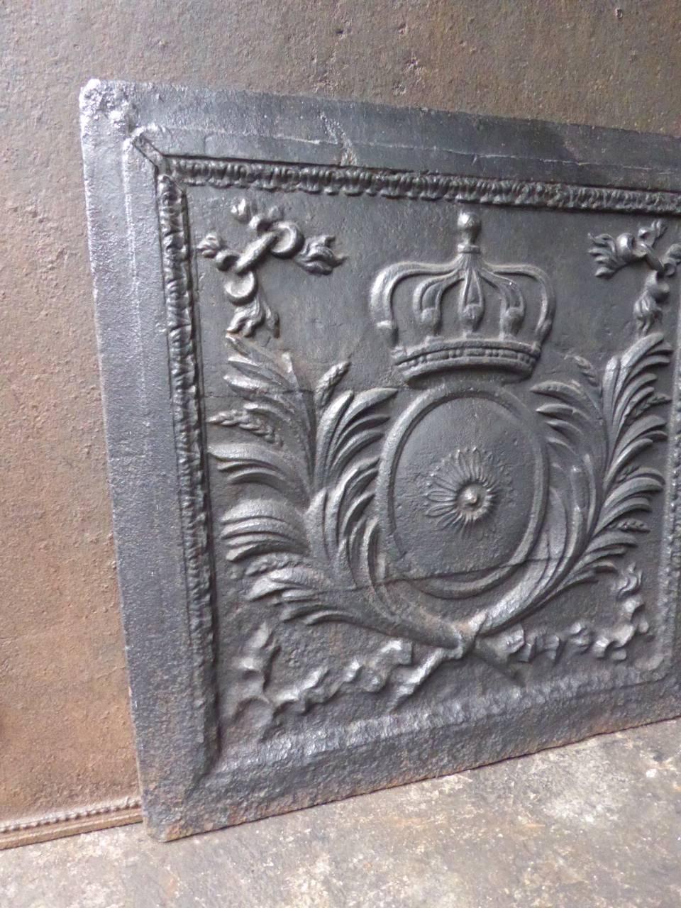 19th century French fireback with the arms of France. 

The sun symbolizes King Louis XIV, the crown stands for royalty and the palm leaves for victory and peace.