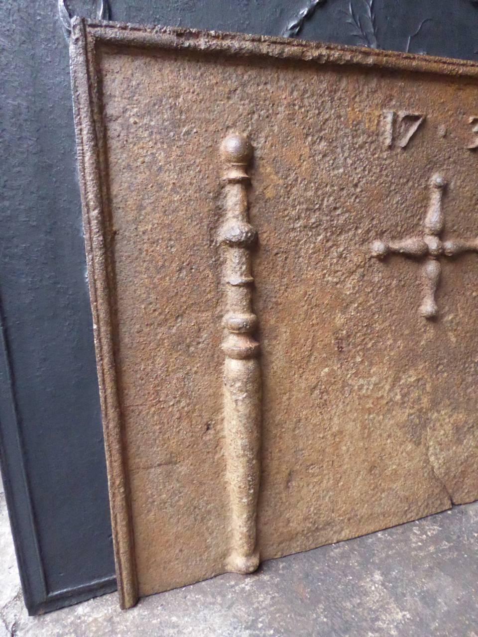 French fireback with two pillars of Hercules, a cross and the date of production 1737.

The pillar refers to the club of Hercules, his favorite weapon. It symbolizes power. Since antiquity the ‘Pillars of Hercules’ are also the name of the