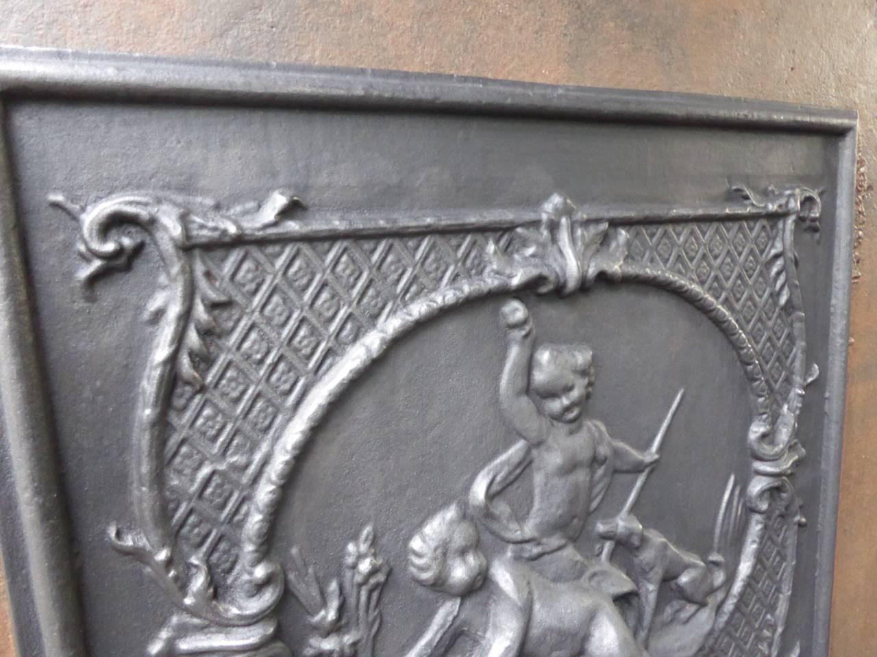 French fireback with two cupids and a dog playing.