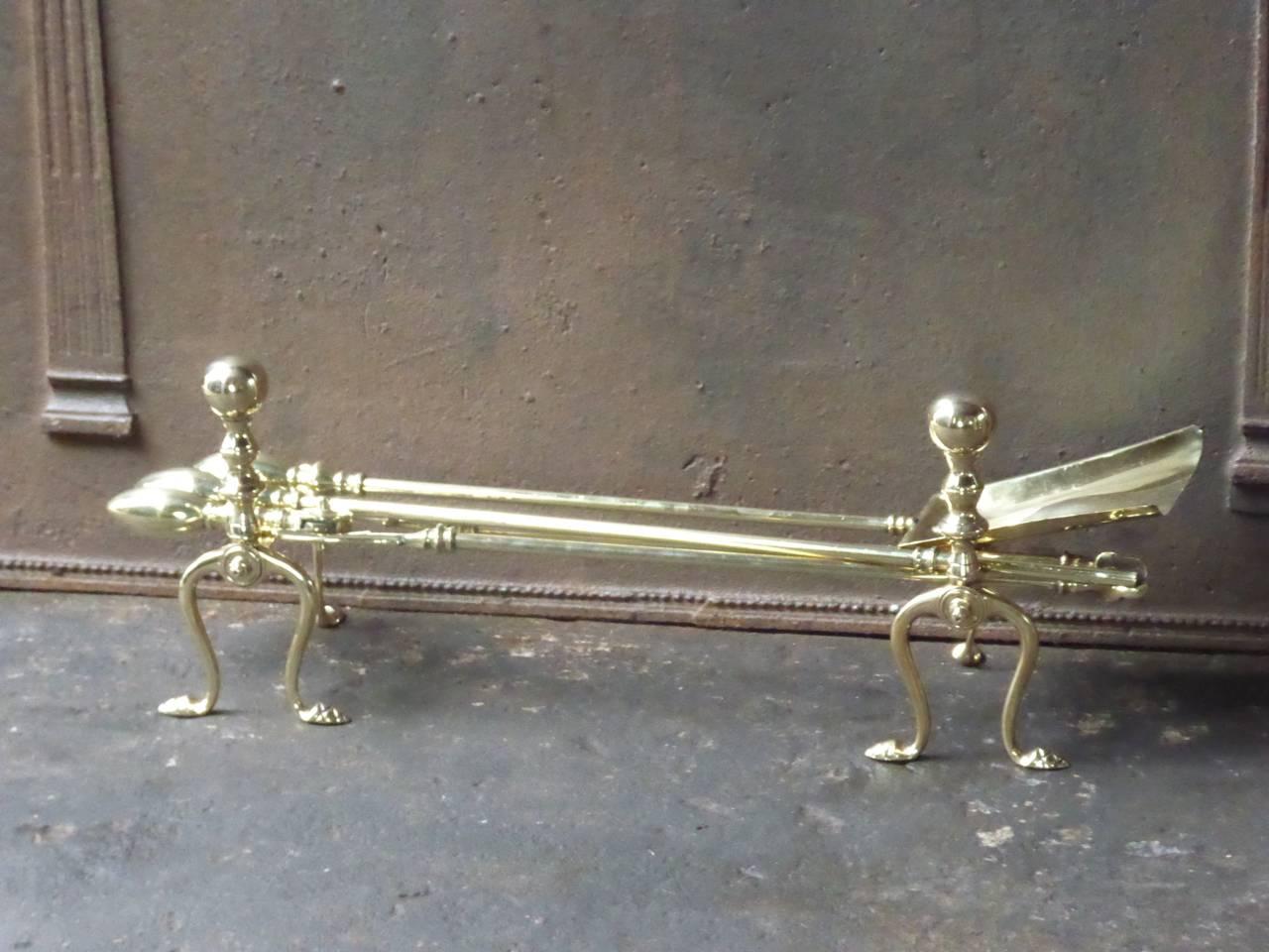 English fireplace tool set or fire irons made of polished brass.