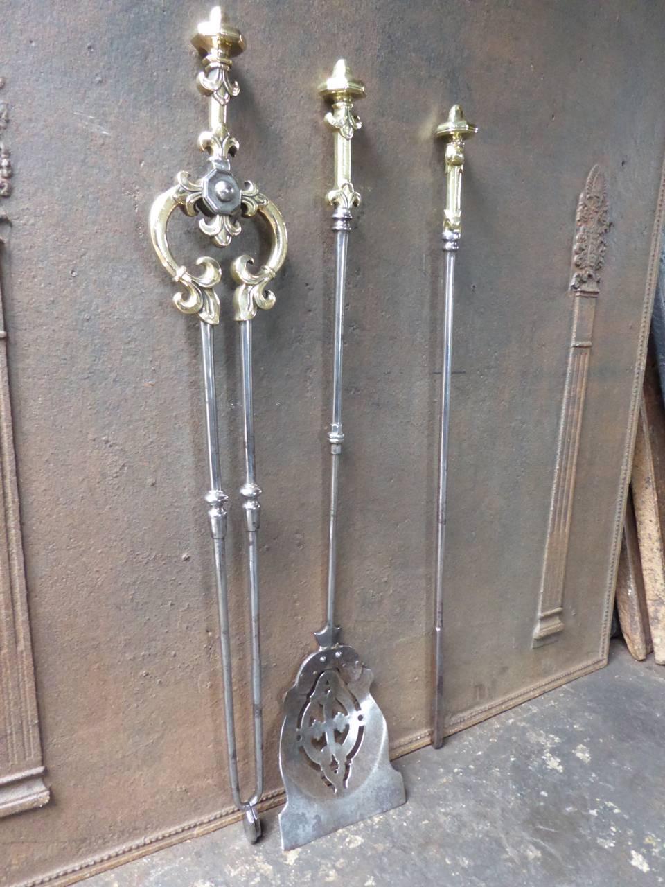 19th century English fireplace tool set or fire irons made of polished steel and polished brass.