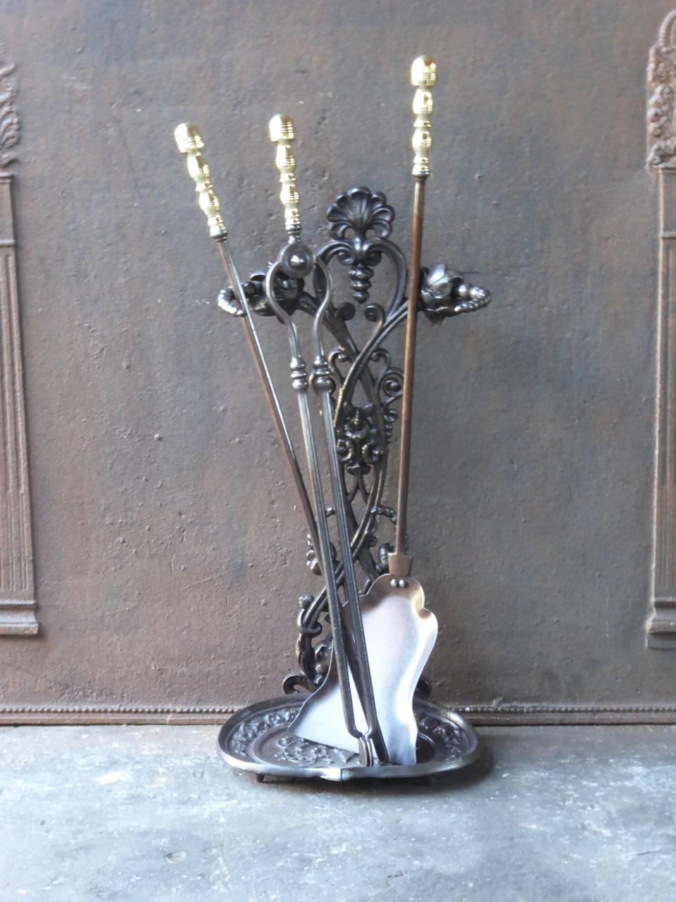 19th century English fireplace toolset made of wrought iron, cast iron and polished brass.