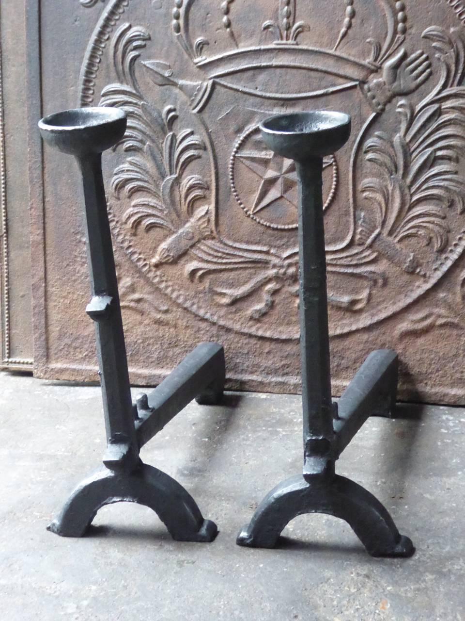 Large French Gothic fire dogs made of cast iron. With spit hooks to grill food and a cup to keep drinks or soup warm. This type of andirons are also called cupdogs.

We have a unique and specialized collection of antique and used fireplace