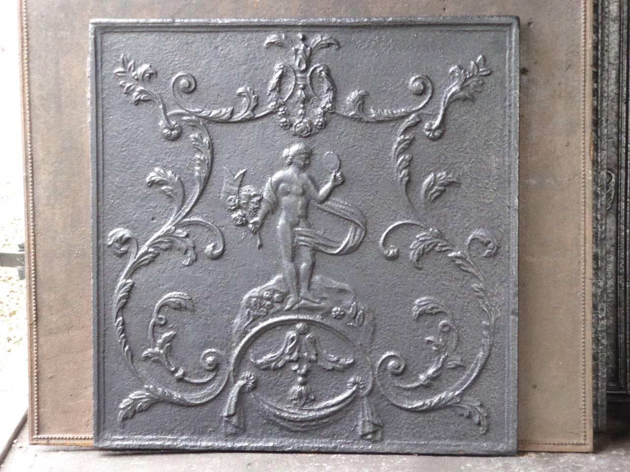 18th century French fireback with the goddess Venus. Venus is holding her mirror and a bunch of flowers. Goddess of love, beauty and fertility.

The fireback is made of cast iron and has a black / pewter patina. The condition is good, no