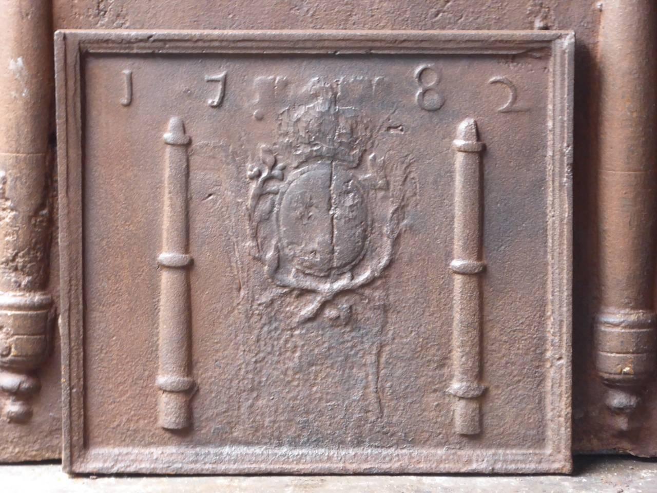 18th century French Louis XV fireback with two pillars and the arms of France. The crown stands for royalty, the olive wreath symbolizes peace and victory and the lilies symbolize French aristocracy. The arms were partially truncated during the