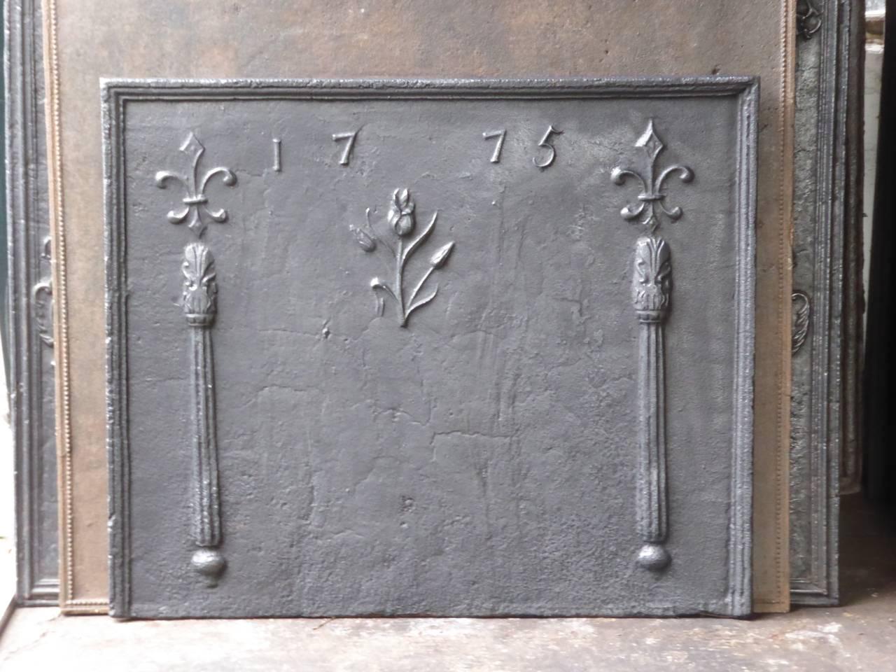 French fireback with two pillars with fleur-de-lys (French lilies) on top and a flower. The fireback is produced in 1775, which is cast in the fireback.

We have a unique and specialized collection of antique and used fireplace accessories