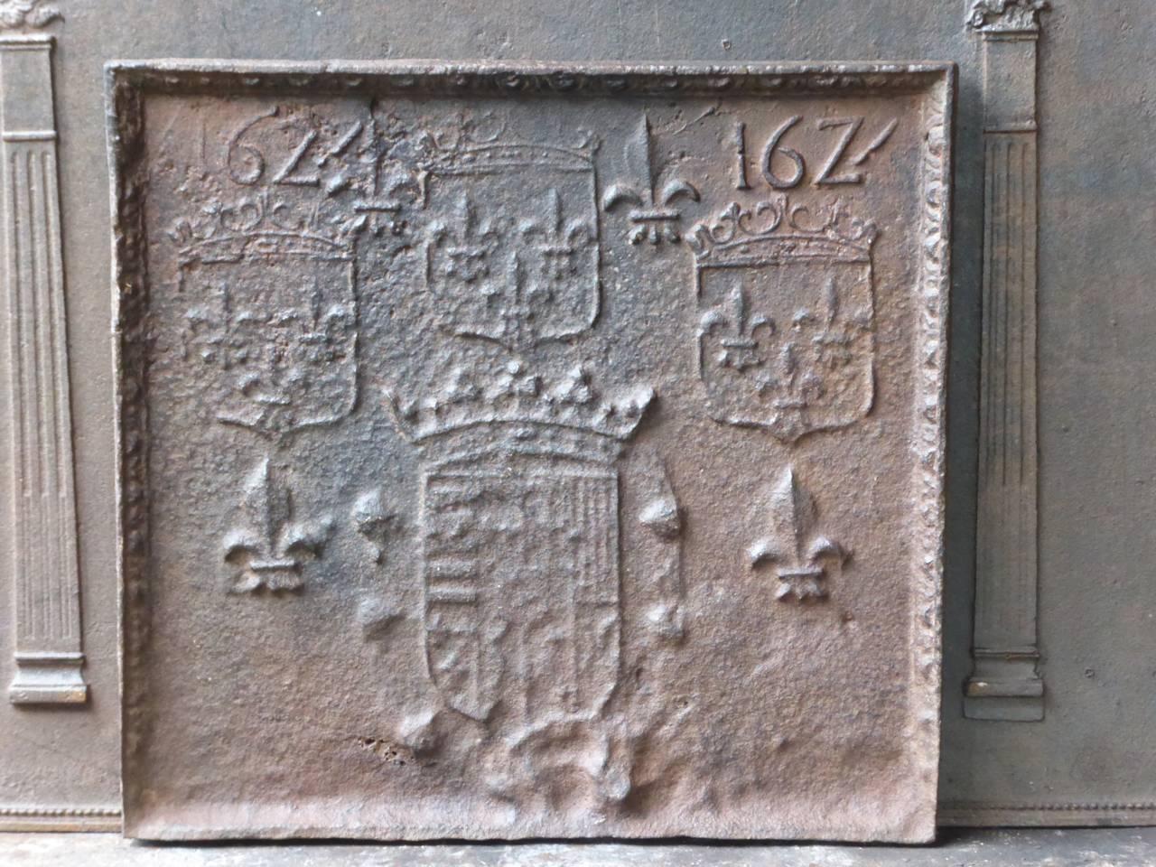 Plaque de cheminée française avec plusieurs armoiries de France et des fleurs de lys. La date de production de la plaque de cheminée, 1624, est également gravée dans la plaque.

La plaque de cheminée est en fonte et a une patine brune naturelle. Sur