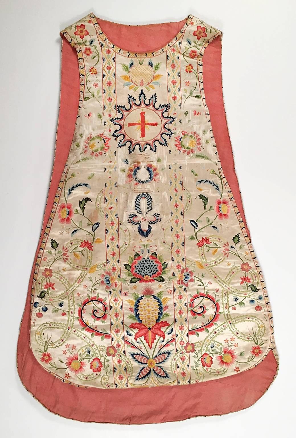 Fiddle back style with floral, pineapple and cross motifs on a crème colored silk satin. Wear on front of chasuble from necklaces. Heavily embroidered in multi-colored silk threads.