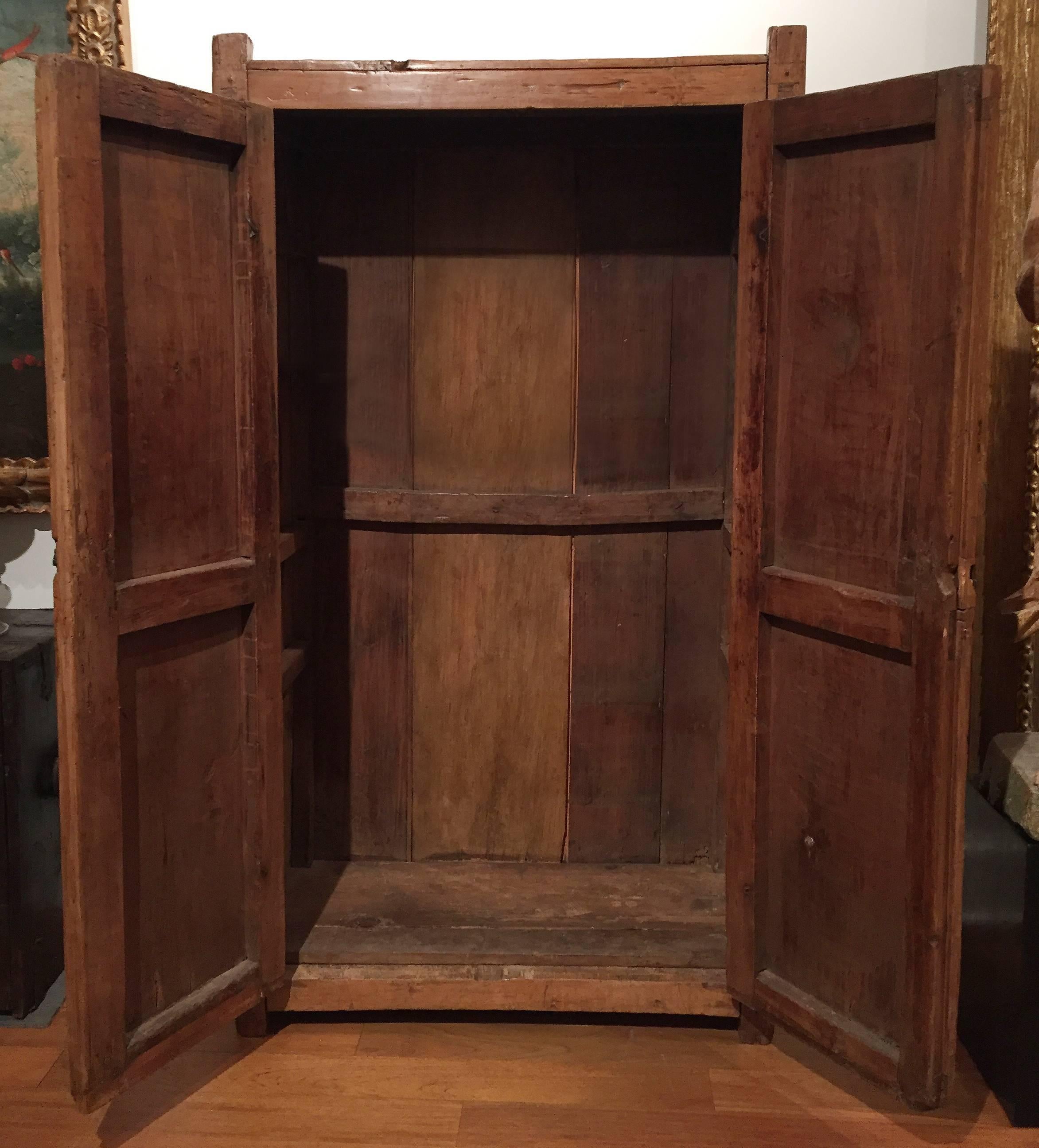 This 18th century Baroque armario o ropero (armoire or wardrobe) is constructed of hand hewn, joined and carved light sabino pine. The iron hinges, lock and lockplate are all hand-forged, as is an occasional nail that was used in antique repair. The