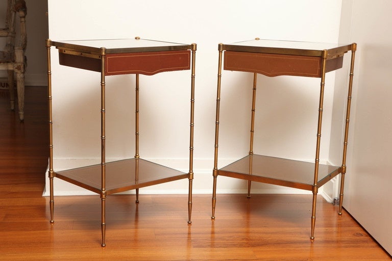 Pair of side tables with slender, two-tier brass frame. Small drawer at the top. Original cognac leather with gold detailing, France, circa 1960s.
