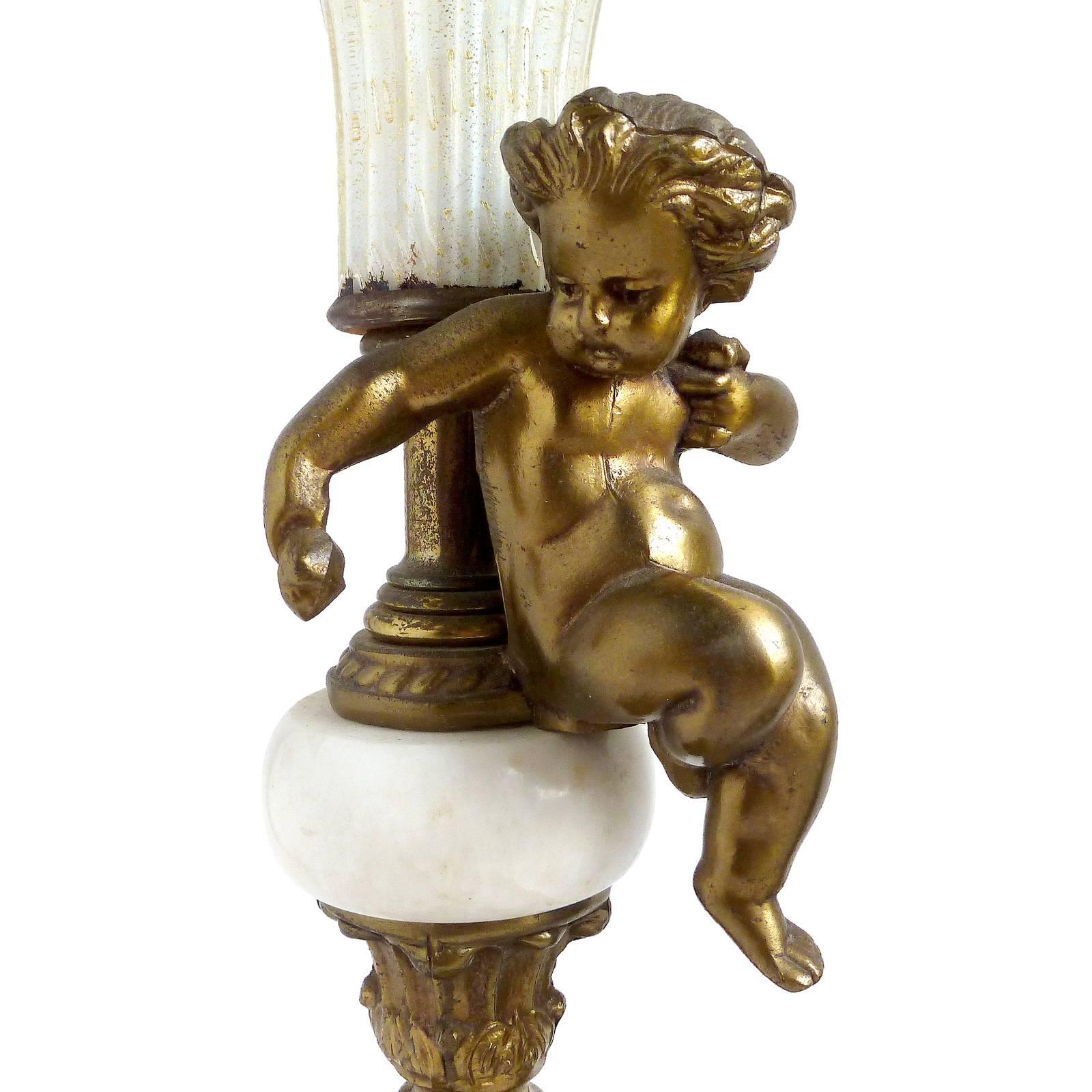 Beautiful decorative cherub lamps, with marble disk, and Murano white gold flecks and bubbles art glass shades. The brass cast metal bases are marked L & L (Loevsky & Loevsky) with number 8238 on each of them. The shades have a ribbed design